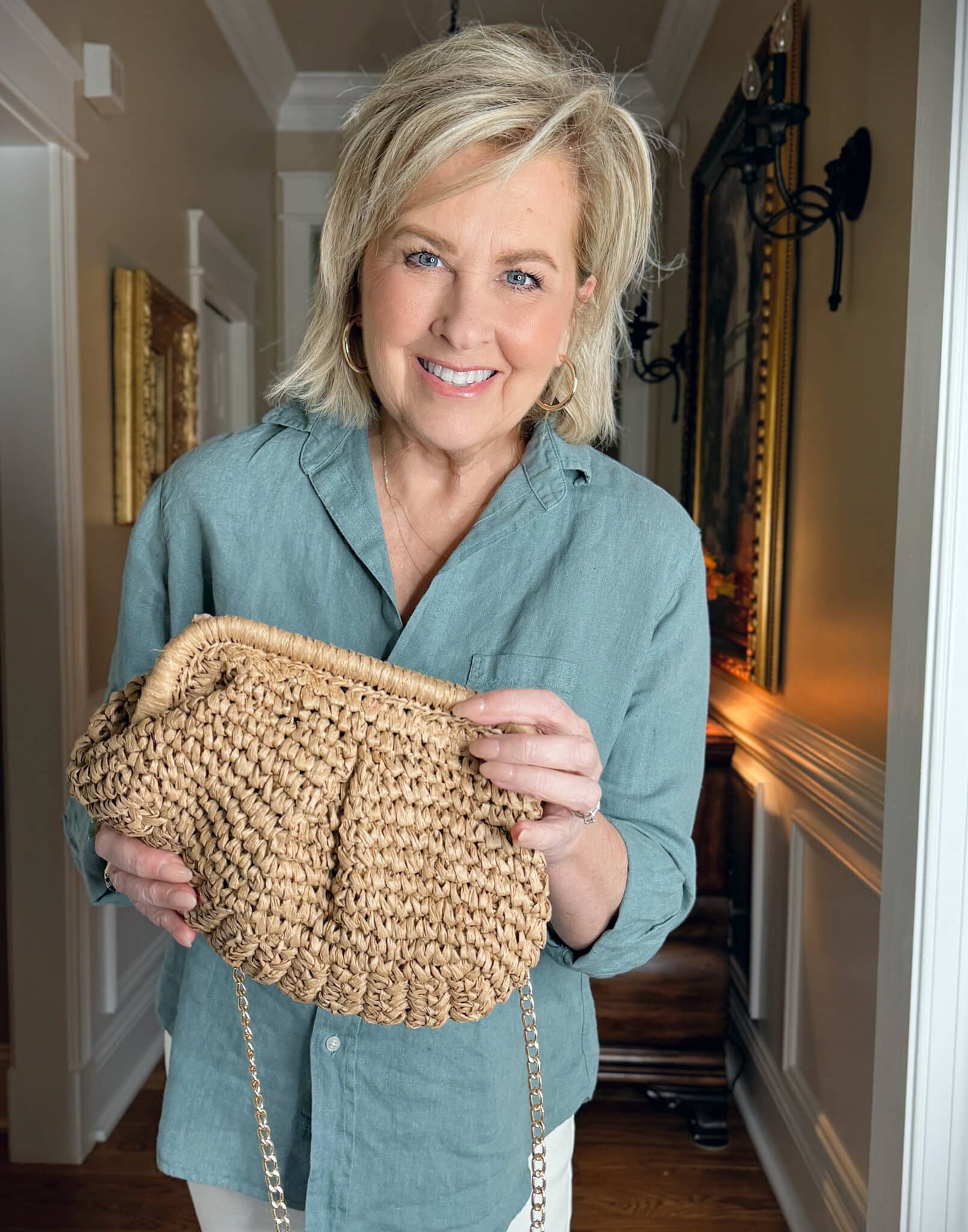 Tania Stephens wearing Frank & Eileen green linen button up shirt and holding a raffia straw clutch