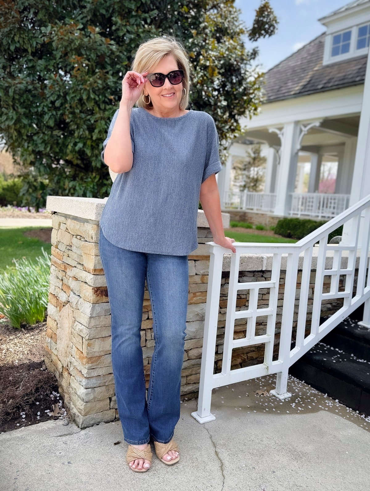 Woman wearing a ribbed knit tee and dark wash bootcut jeans with sunglasses, styled for a casual spring day