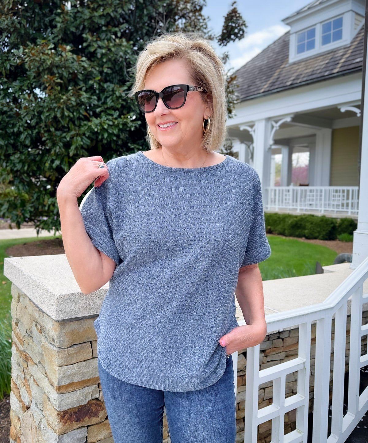 a woman wearing sunglasses and a blue shirt