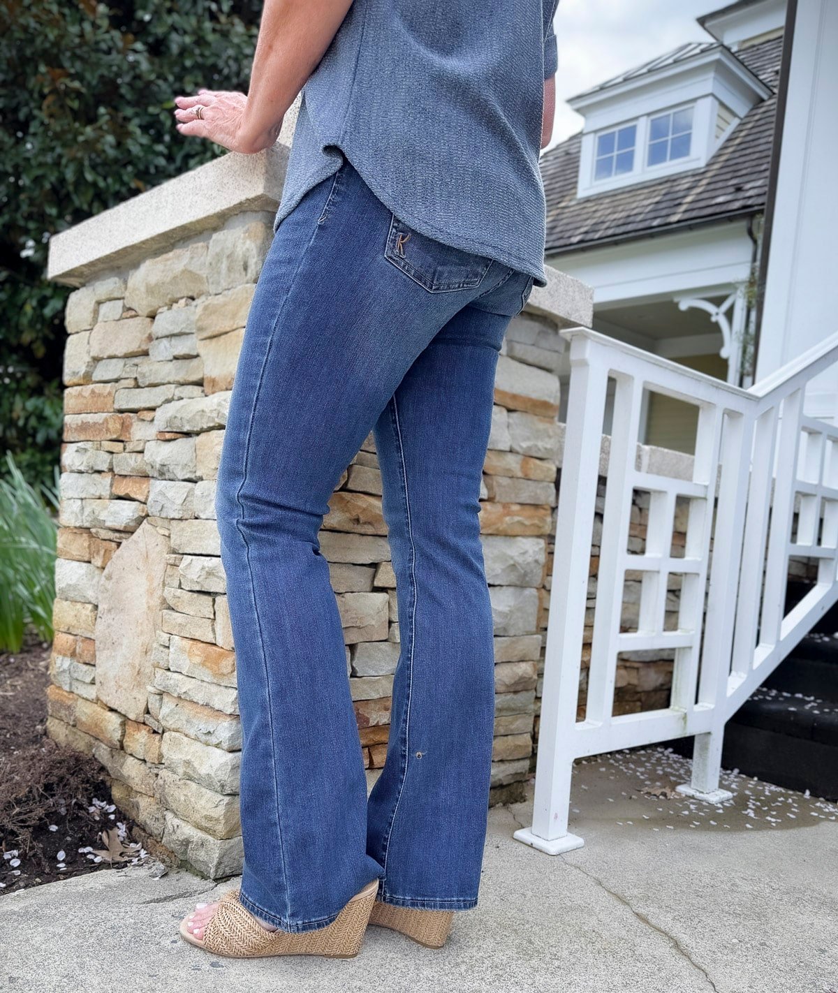 a woman wearing jeans and a blue/grey shirt