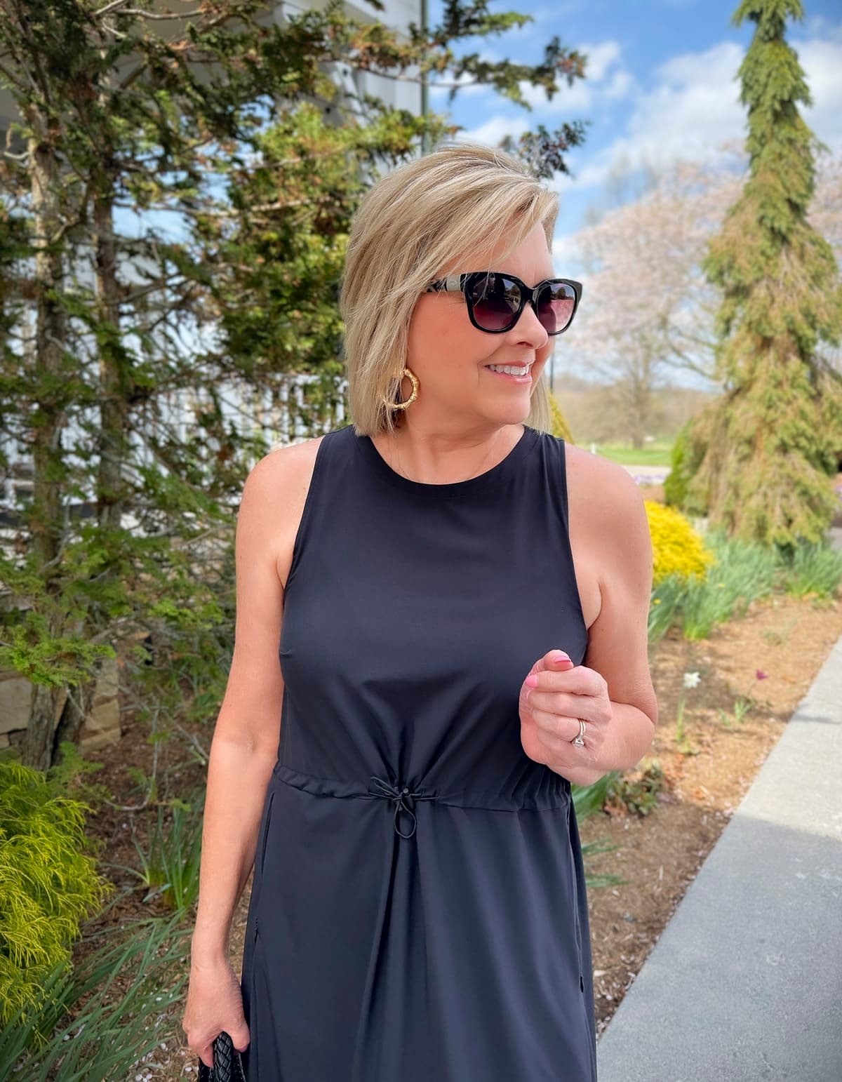 a woman wearing sunglasses and a black dress