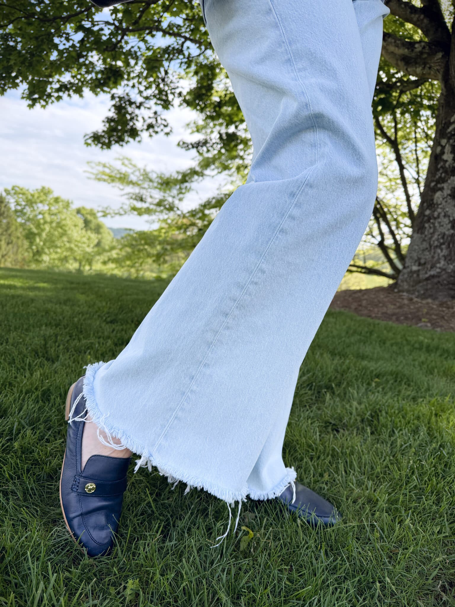 Tania Stephens wearing light wash jeans with a frayed hem