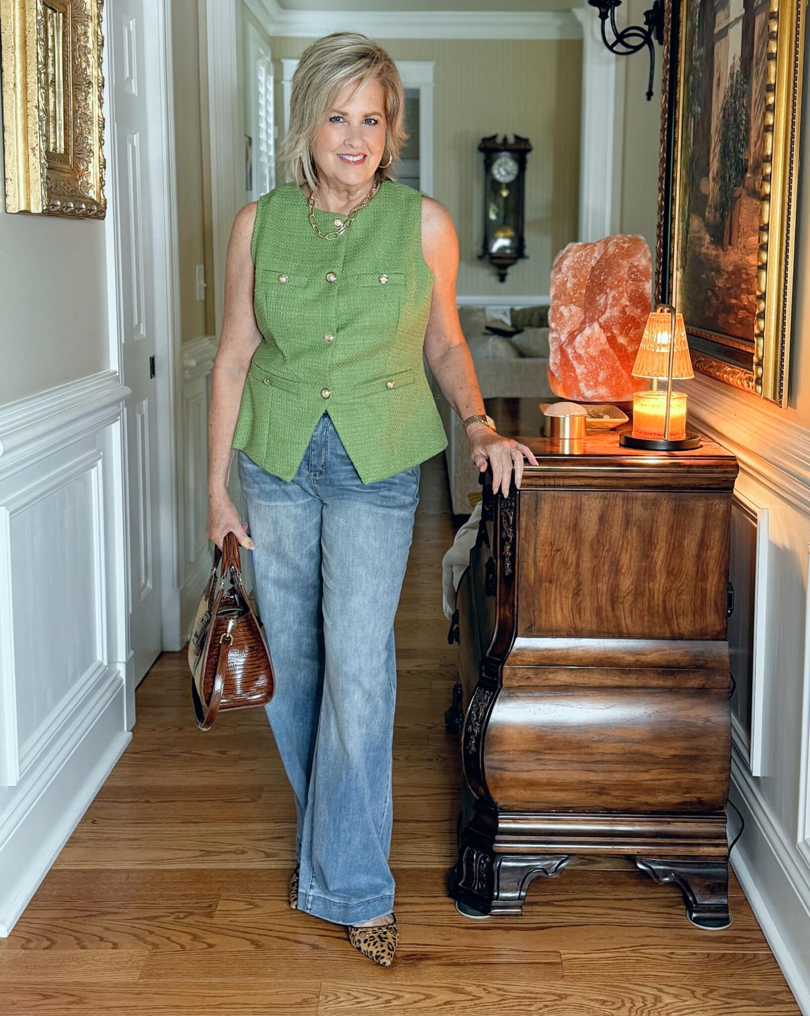 Woman wearing a green tweed vest for summer with faded jeans
