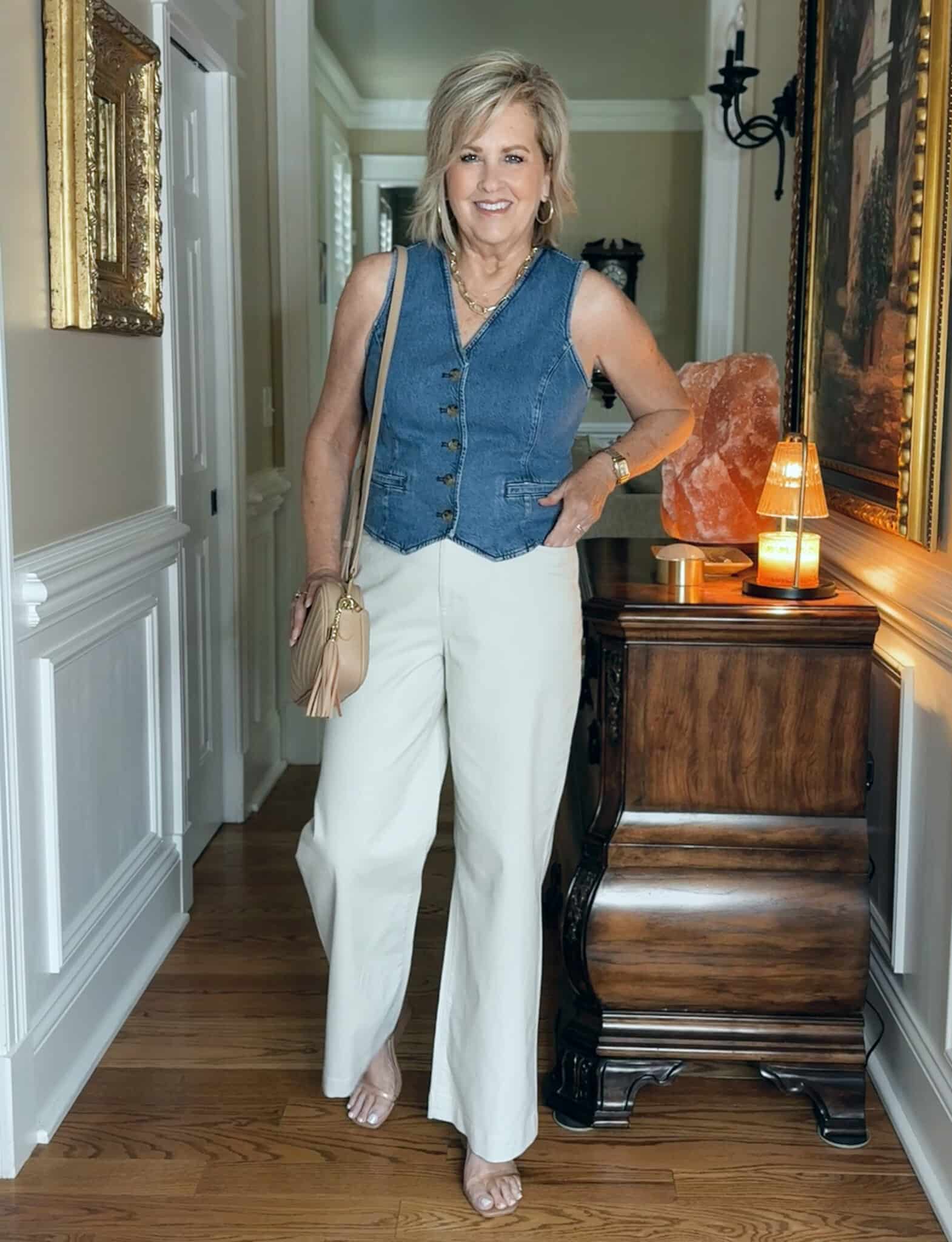 Woman wearing a denim vest for summer with beige chino pants