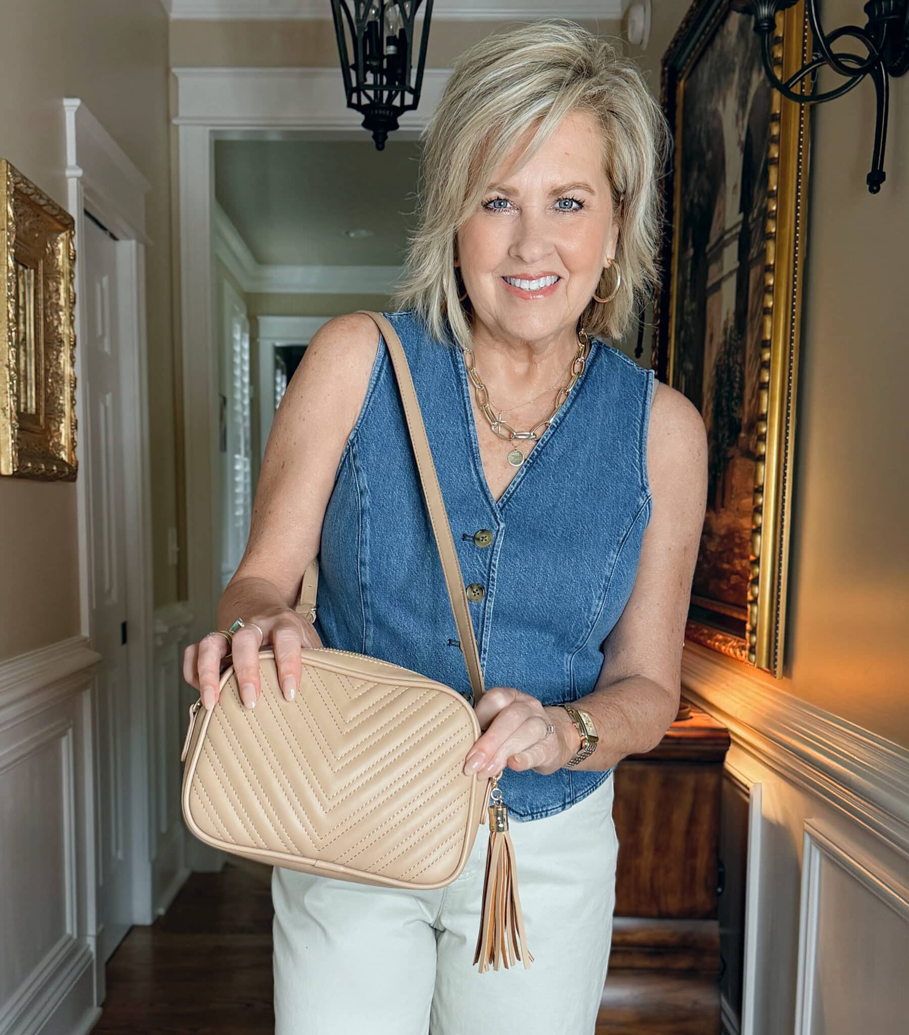 Woman wearing a denim vest and holding a quilted crossbody