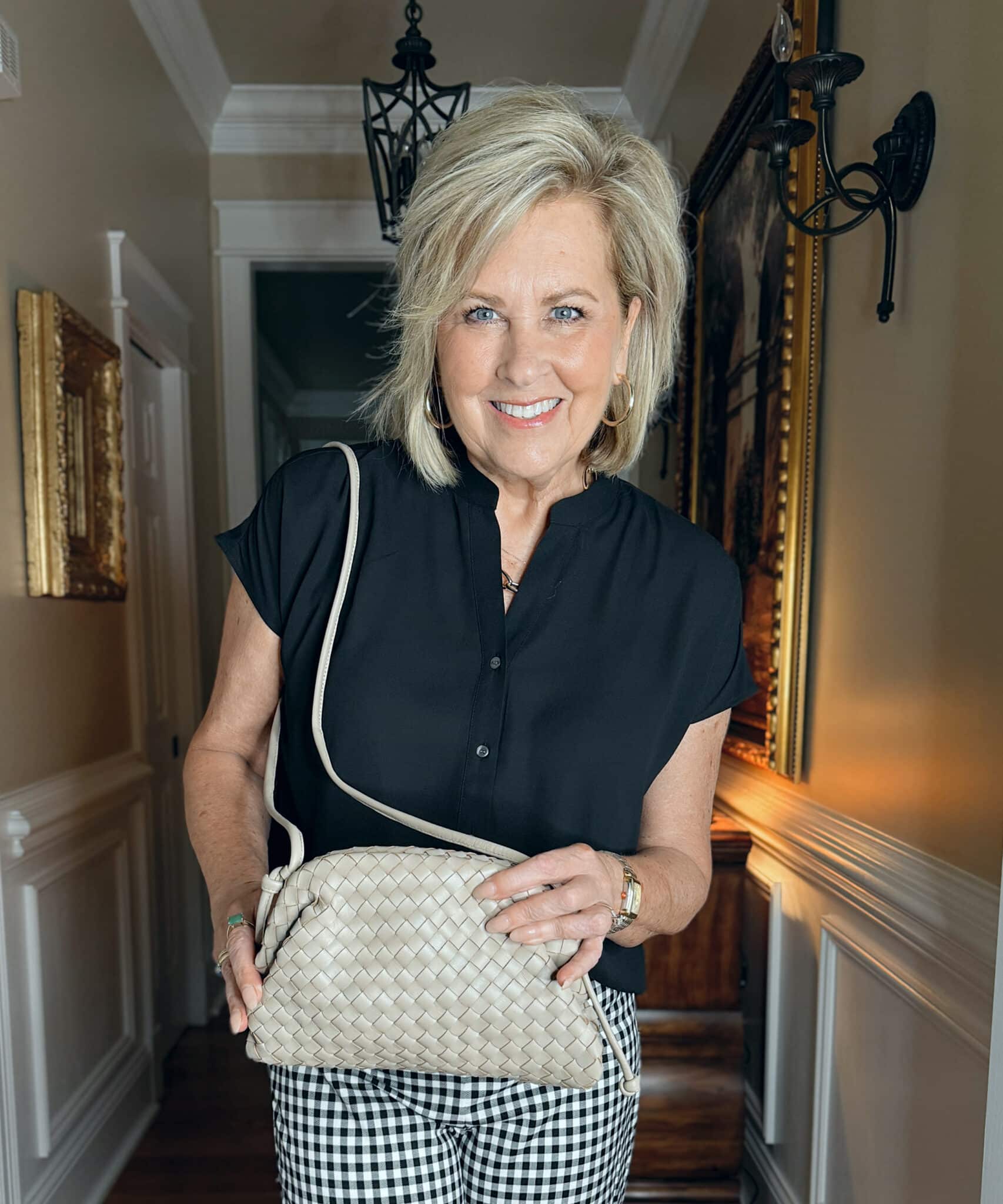 woman wearing Ann Taylor black top and a woven handbag