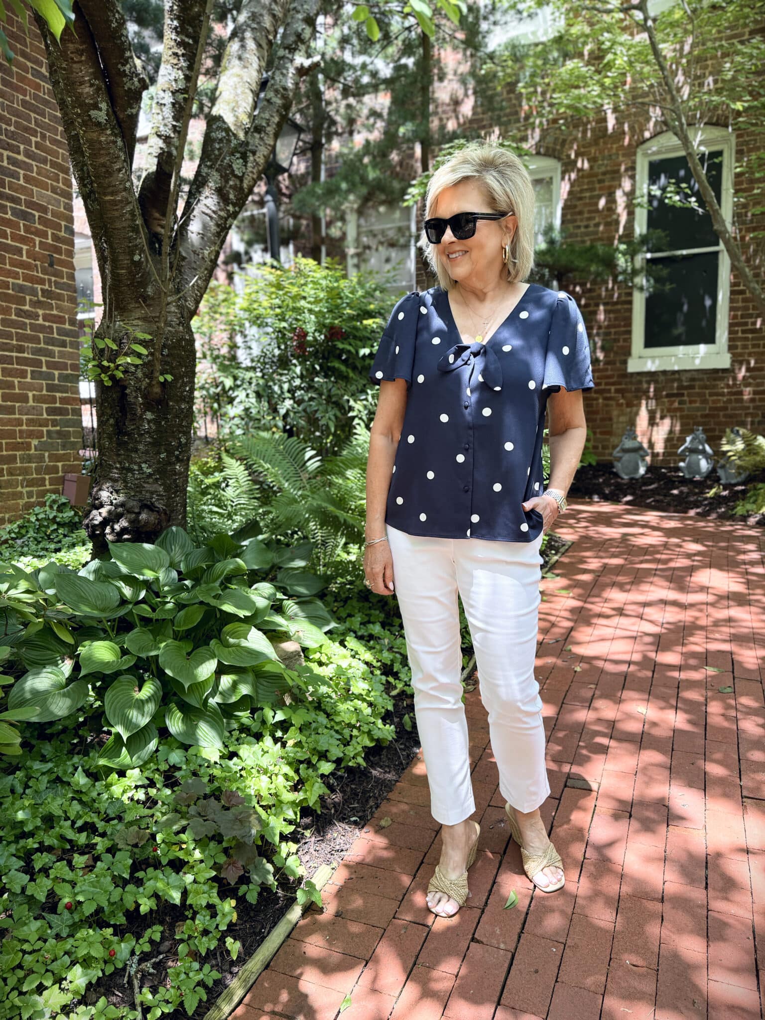 woman wearing a summer outfit from Kohl's, polka dot shirt and white pants