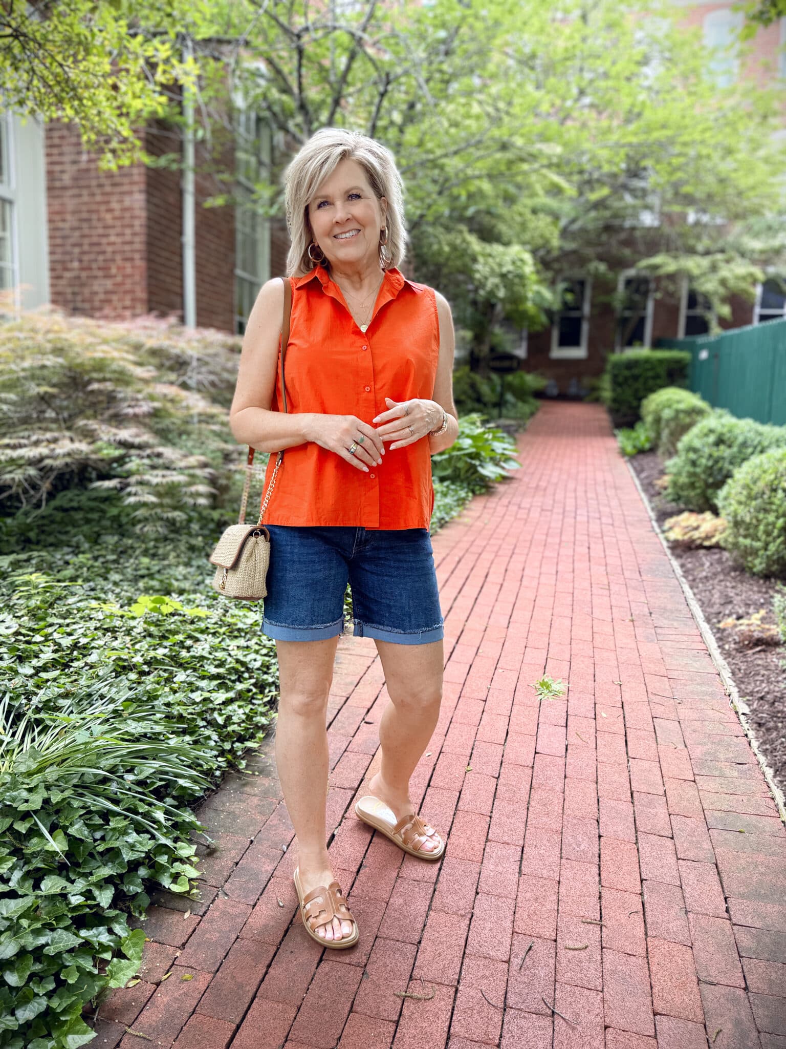 woman wearing a sleeveless orange top and cuffed denim shorts for summer from Nordstrom Rack