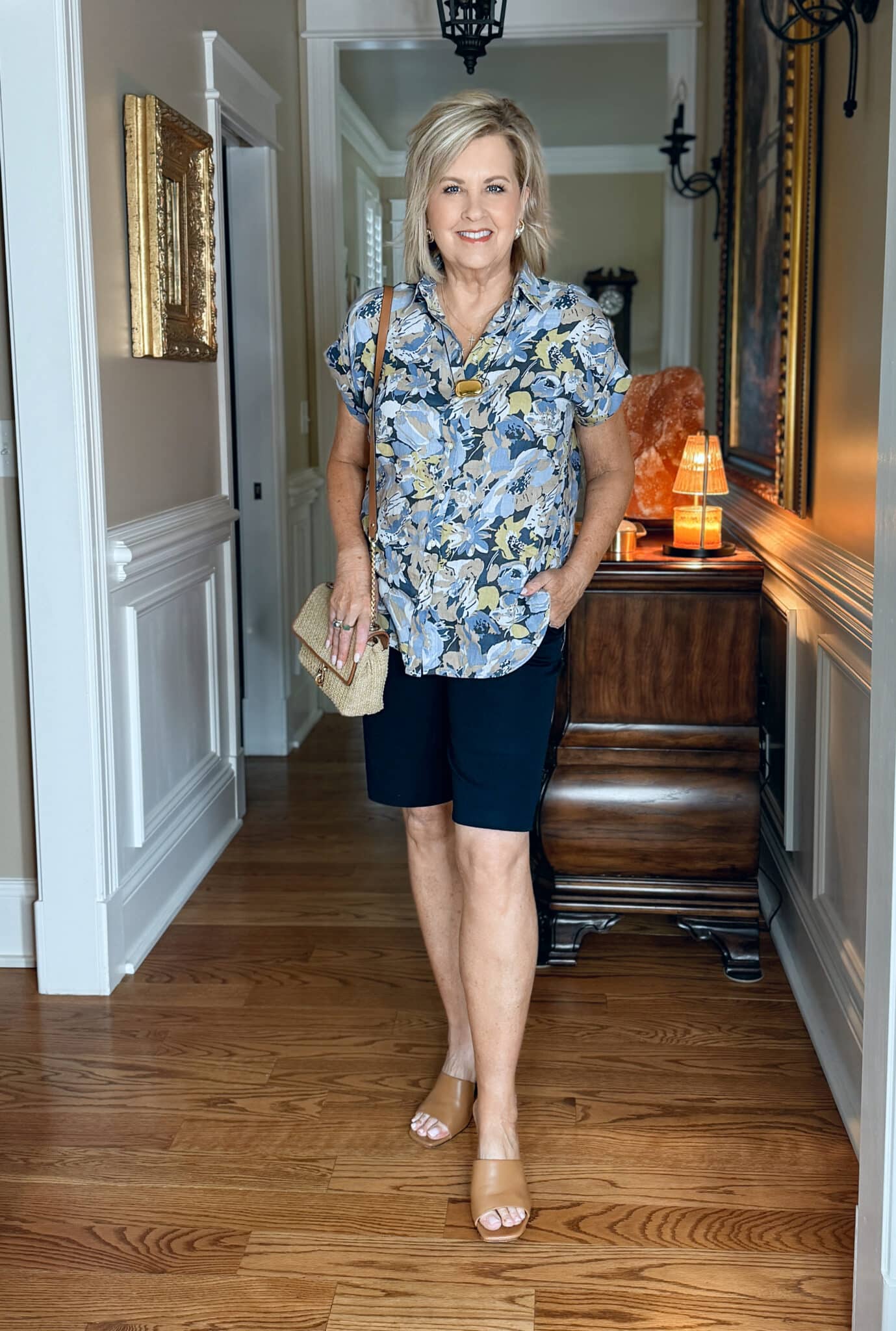 woman wearing a printed button shirt with navy Bermuda shorts