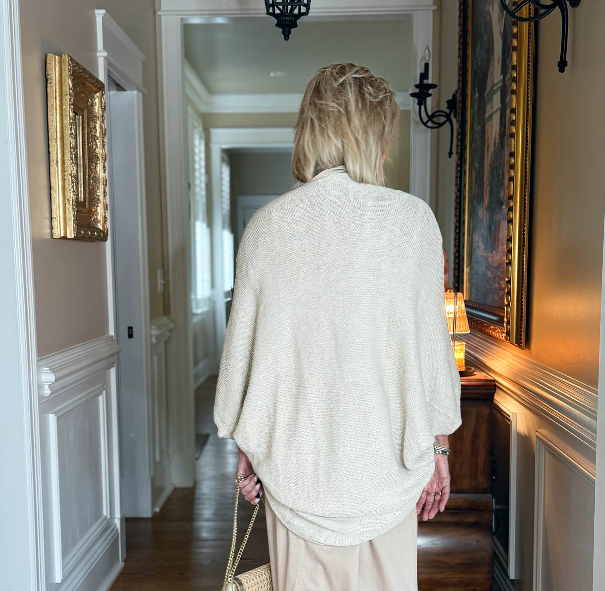 the back of a woman wearing long beige shrug