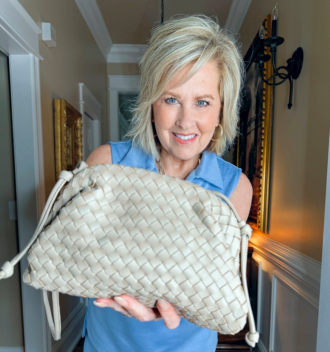 woman holding a woven handbagq from Quince