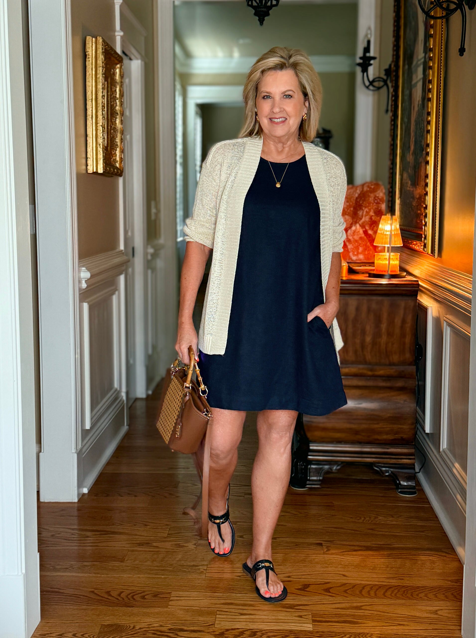 Tania wearing a versatile navy linen shift dress with a beige cardigan