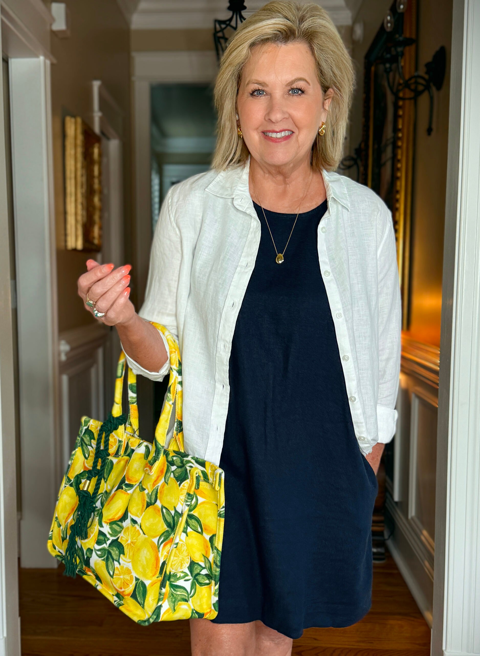 Tania wearing a versatile navy dress with a white linen shirt and lemon tote