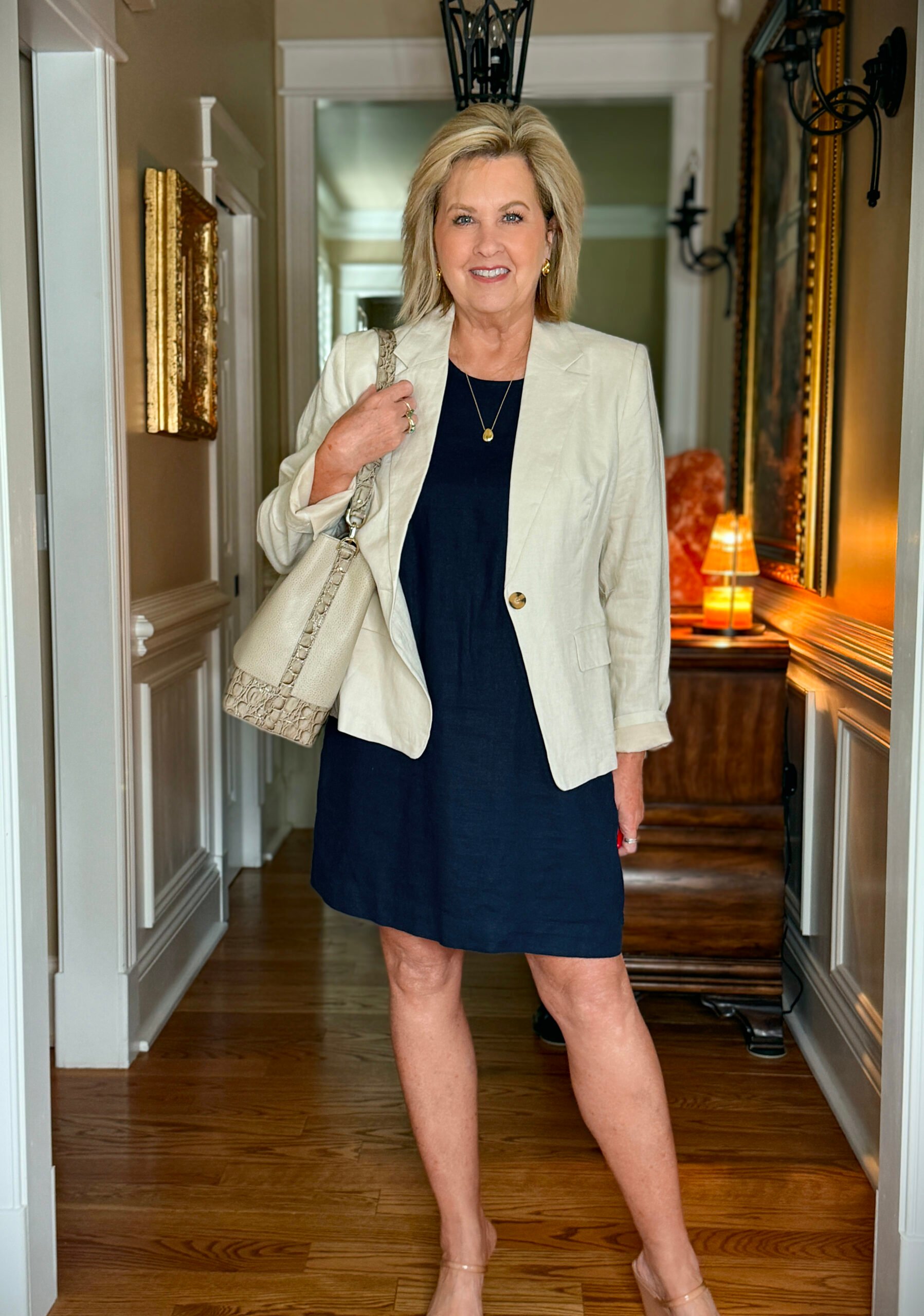 Tania styled in a structured linen blazer over her dress with two-strap wedge sandals and the Celina bucket bag, creating a polished and elevated look.