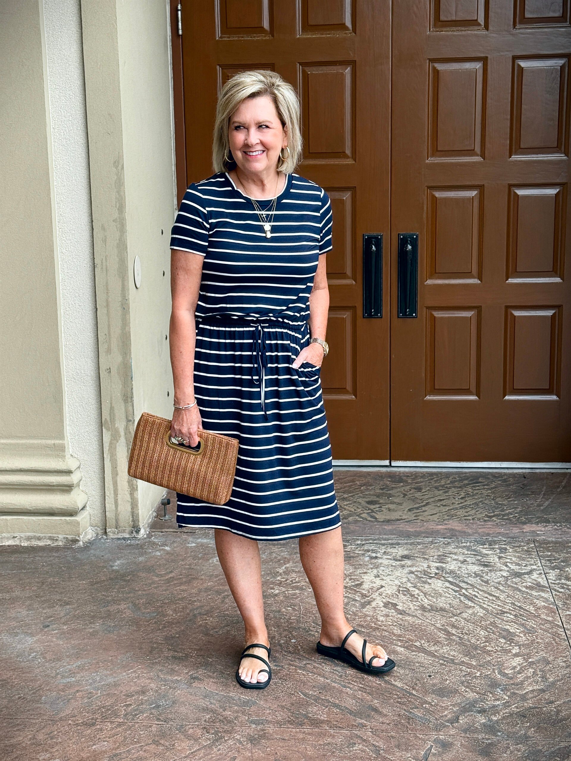 Tania wearing a navy & white striped dress while on vacation at the beach