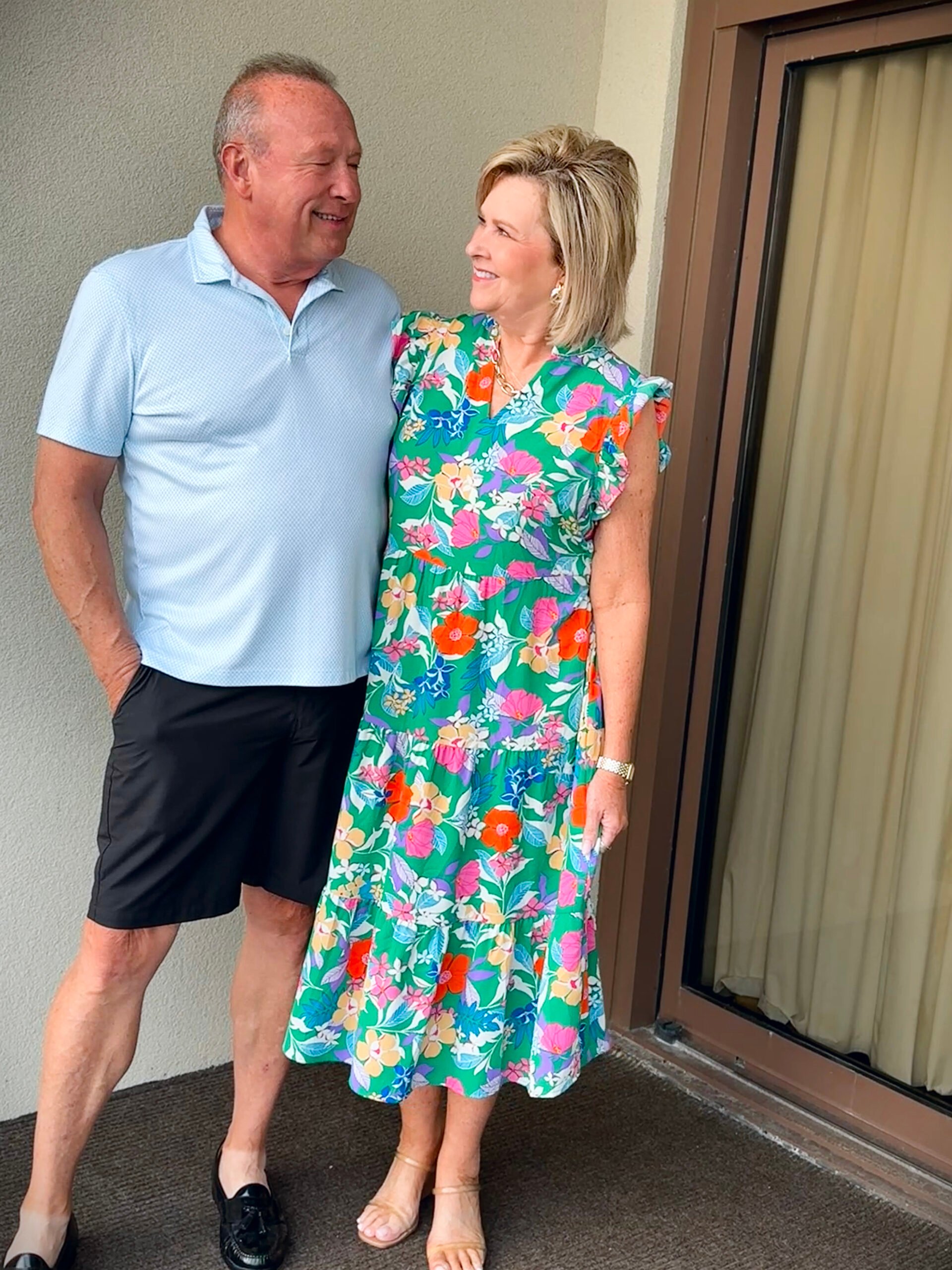 Joe and Tania standing on the hotel balcony while on vacation at the beach