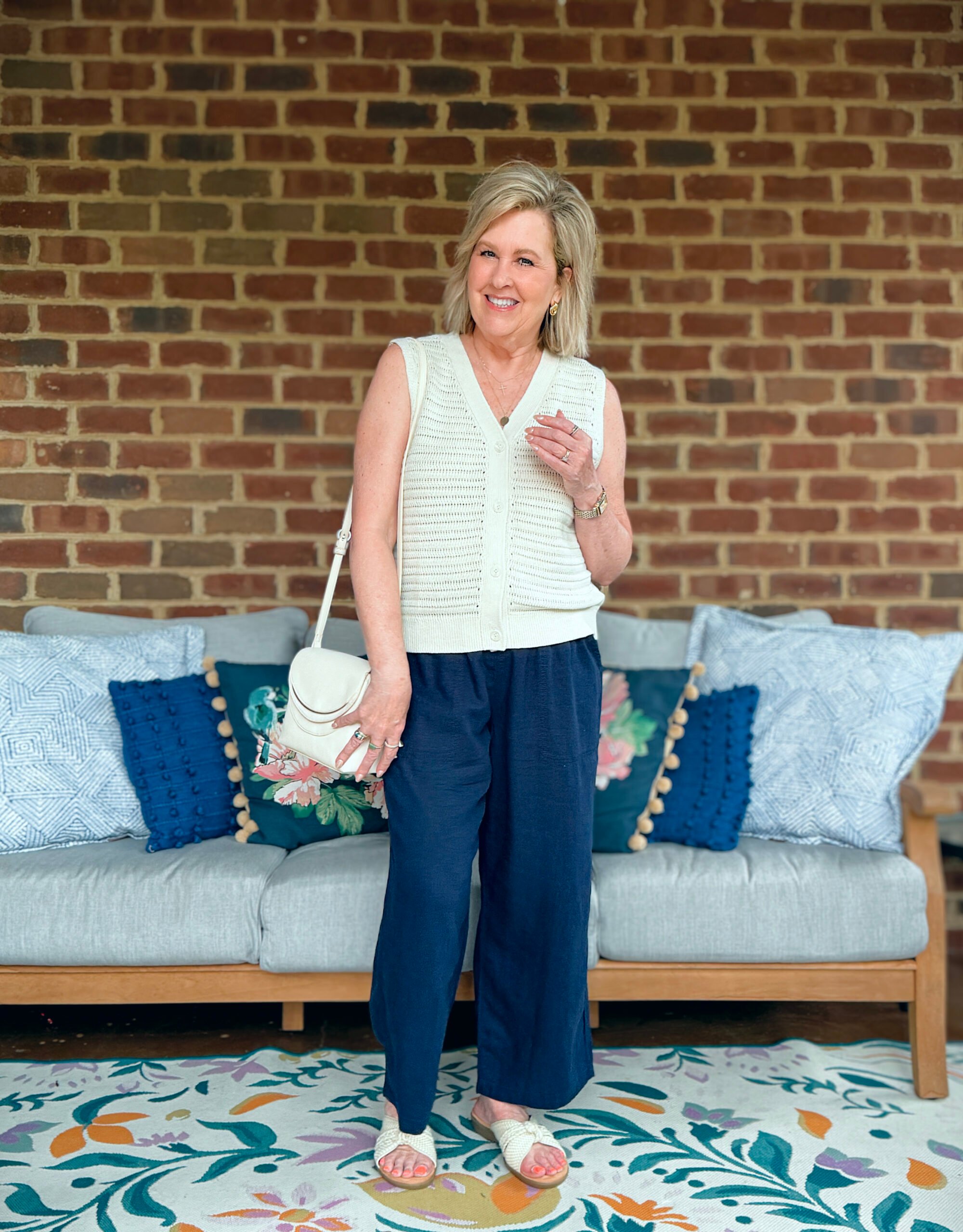 Tania Stephens wearing a neutral sweater vest and navy wide leg pants from Kohls