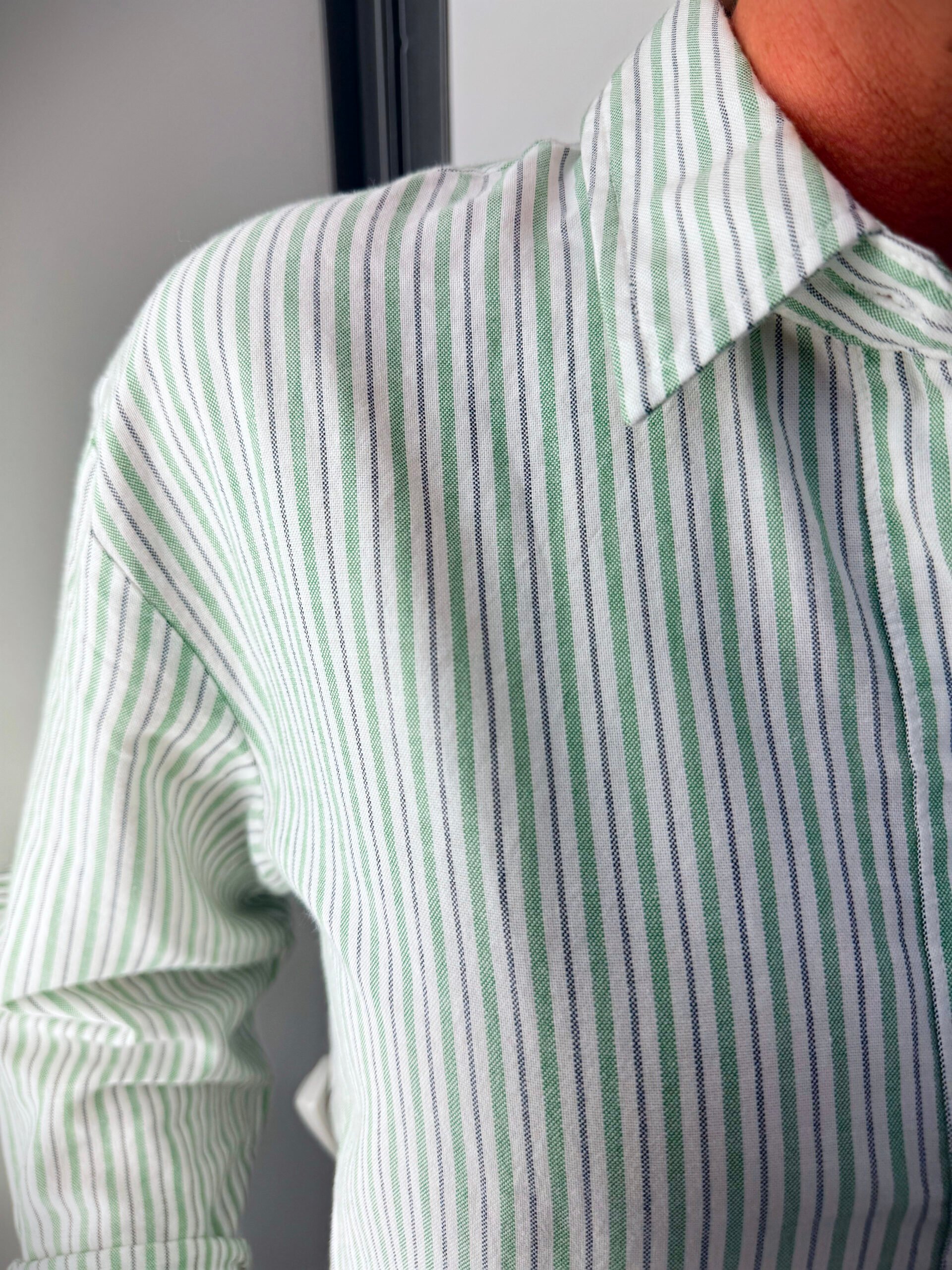 A green and white striped button up shirt