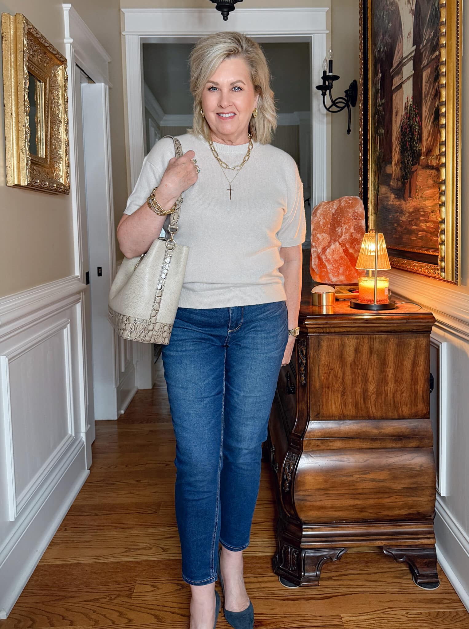 Ivory short sleeve cashmere sweater styled with jeans and bucket bag.
