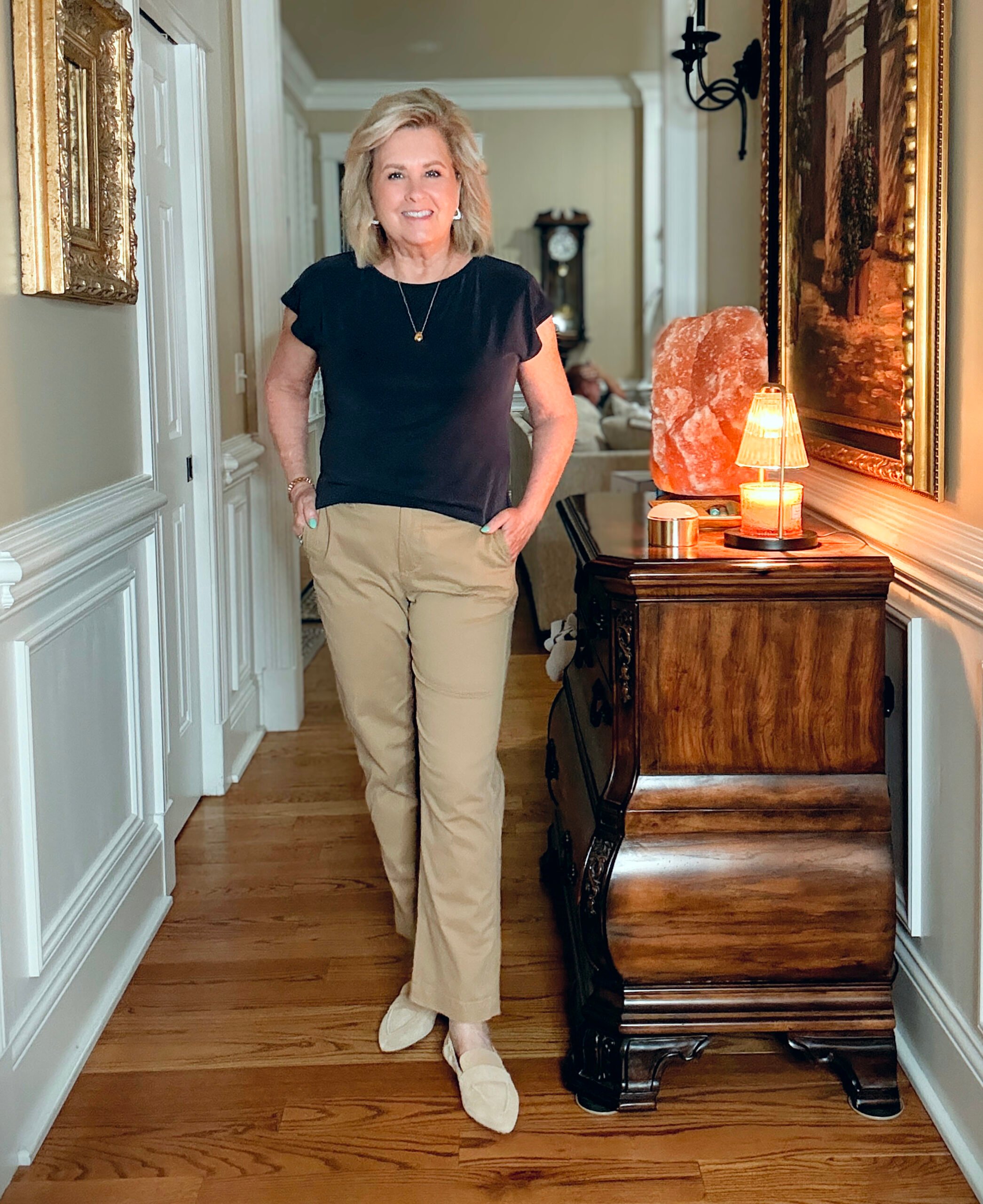 Tania Stephens in a hallway wearing a navy tee and a pair of chinos from J.Crew Factory