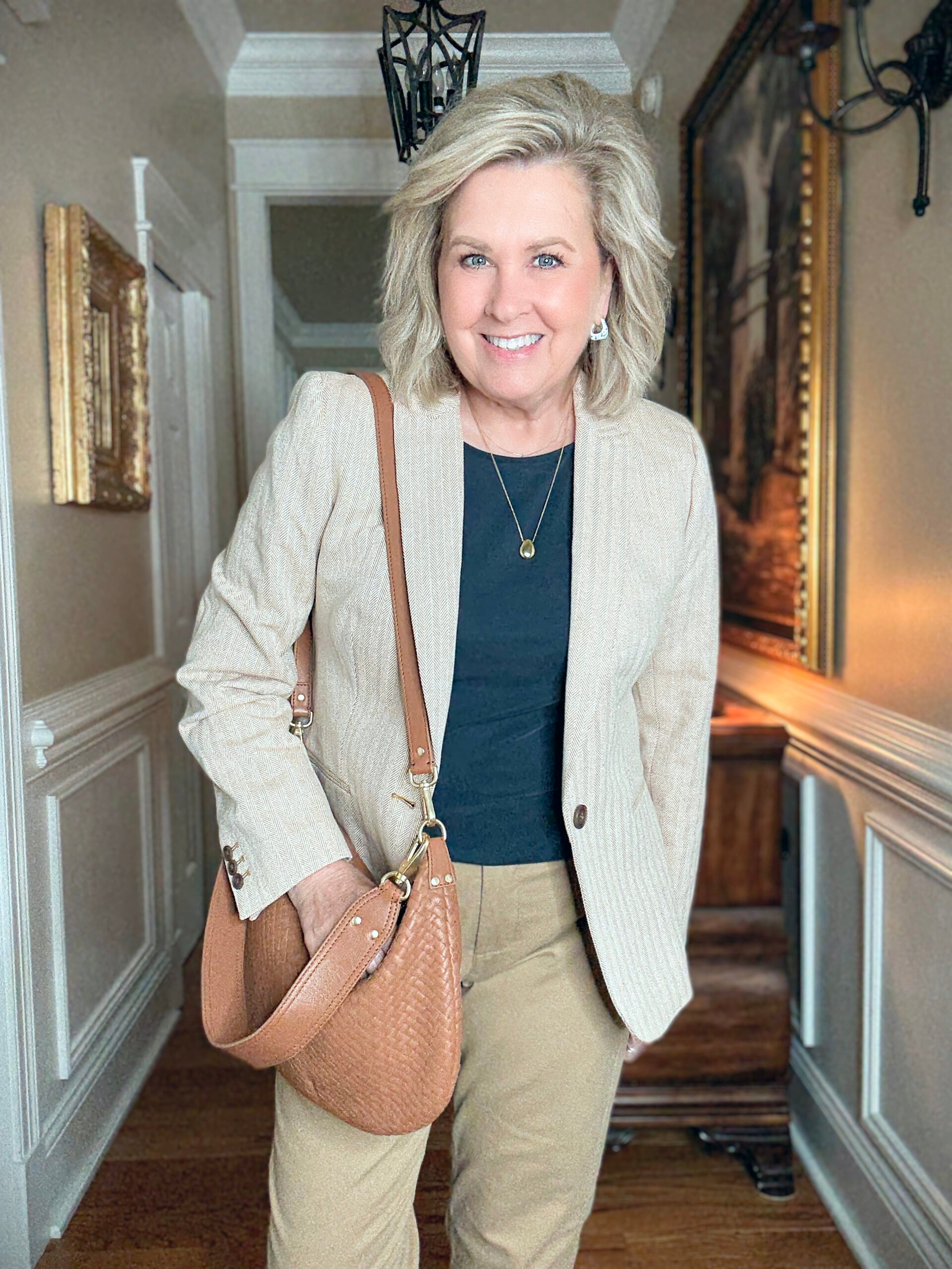 Tania Stephens in a hallway wearing a navy tee and a herringbone blazer from J.Crew Factory