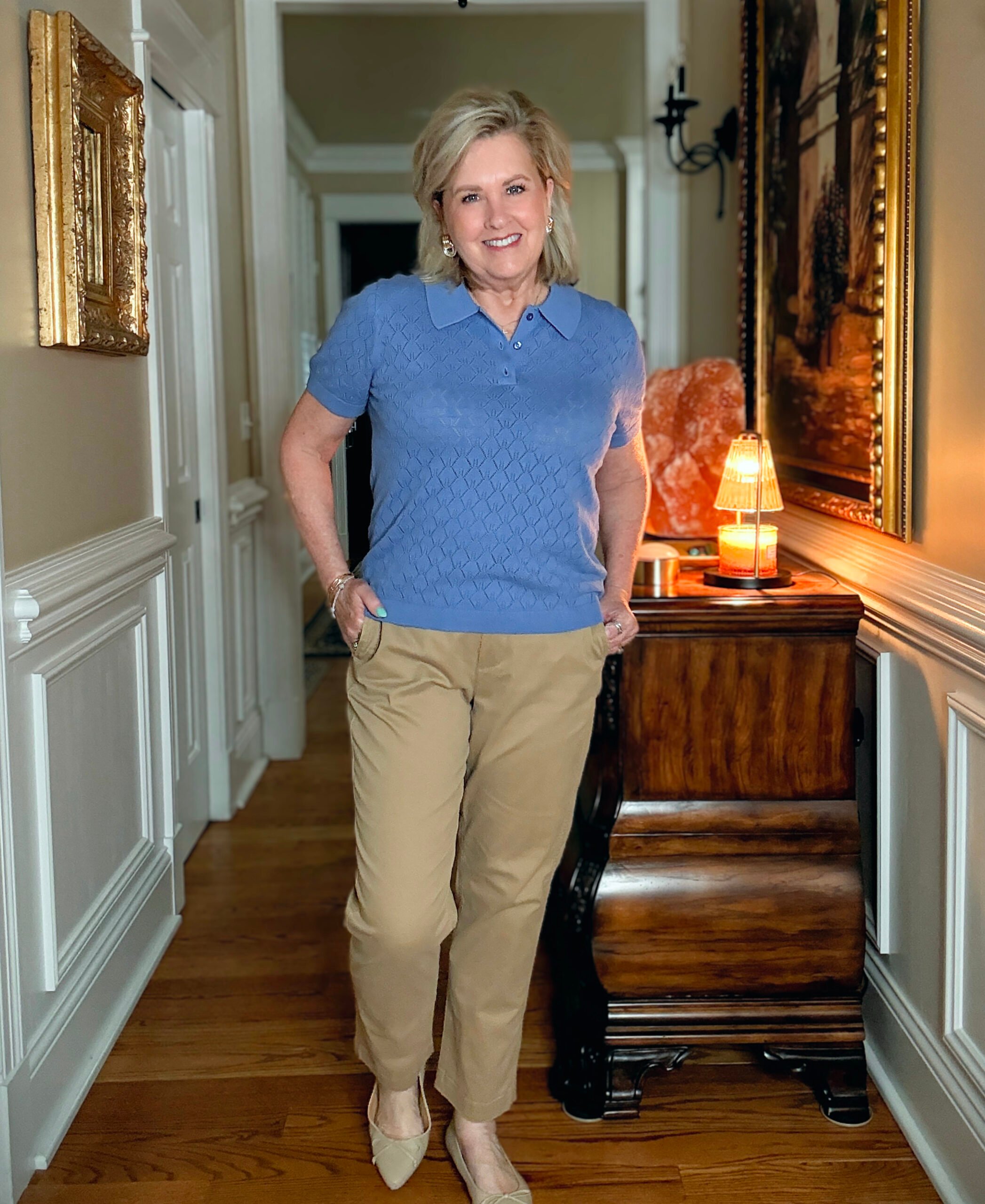 Tania Stephens in a hallway wearing a pointelle collared sweater and a pair of chinos from J.Crew Factory