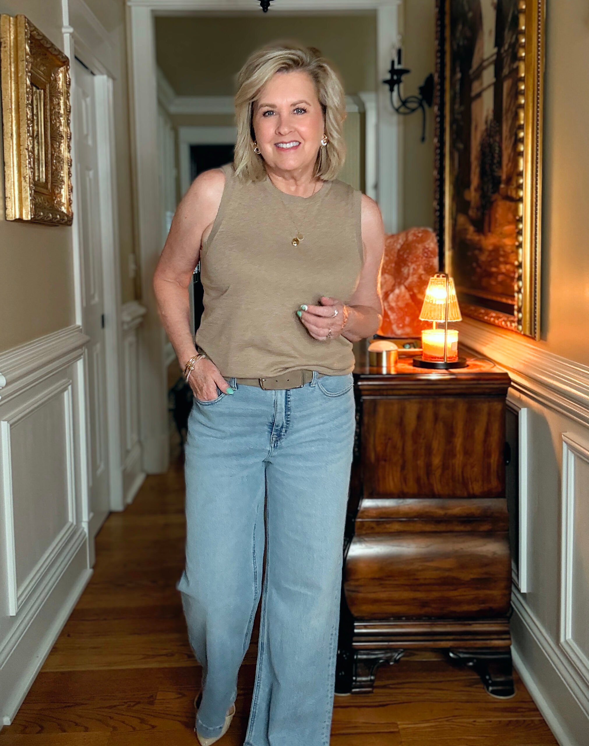 Tania Stephens in a hallway wearing a beige shell and a pair of wide leg jeans