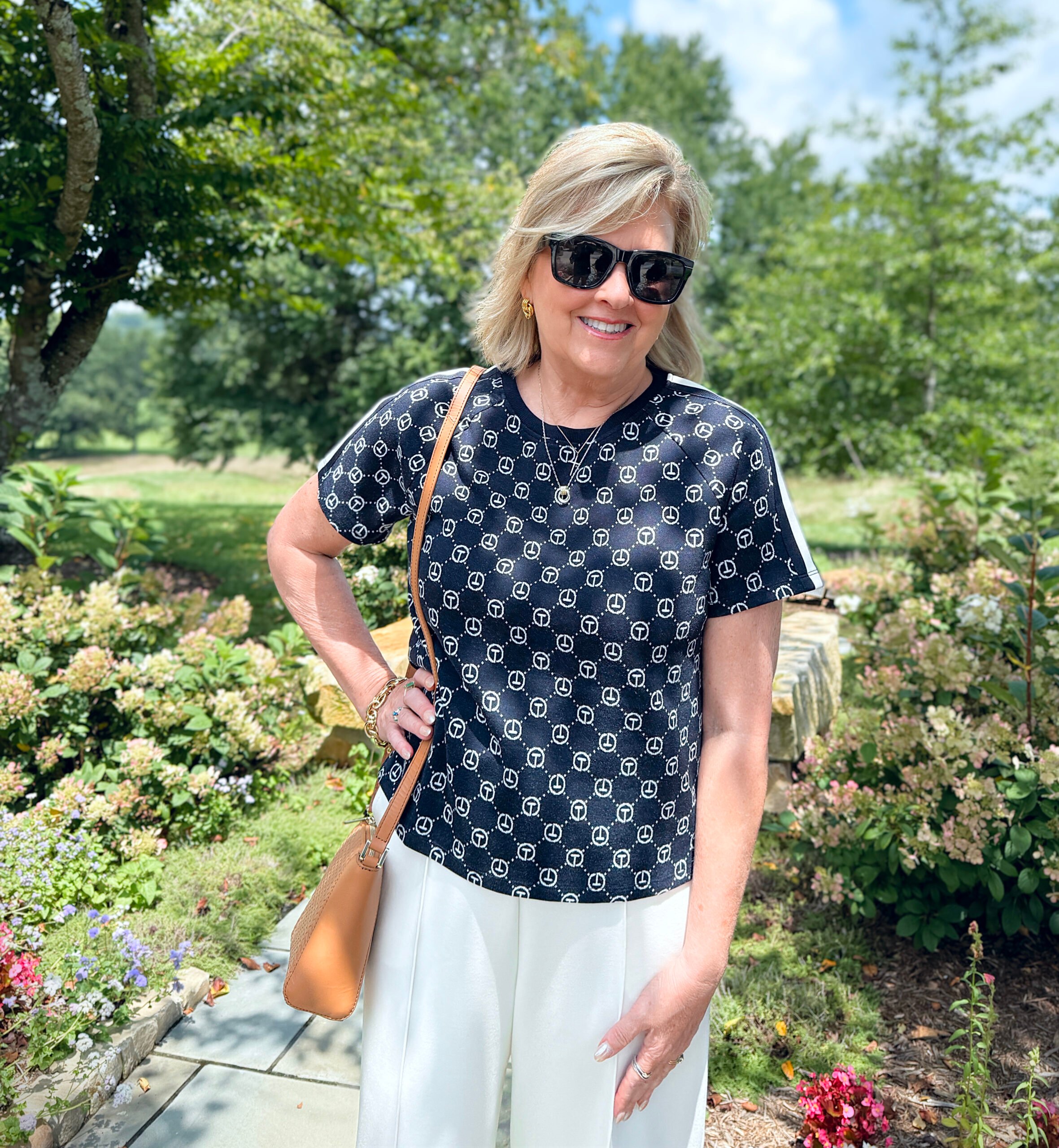 Tania Stephens walking on a garden path in a navy blue top by T By Talbots