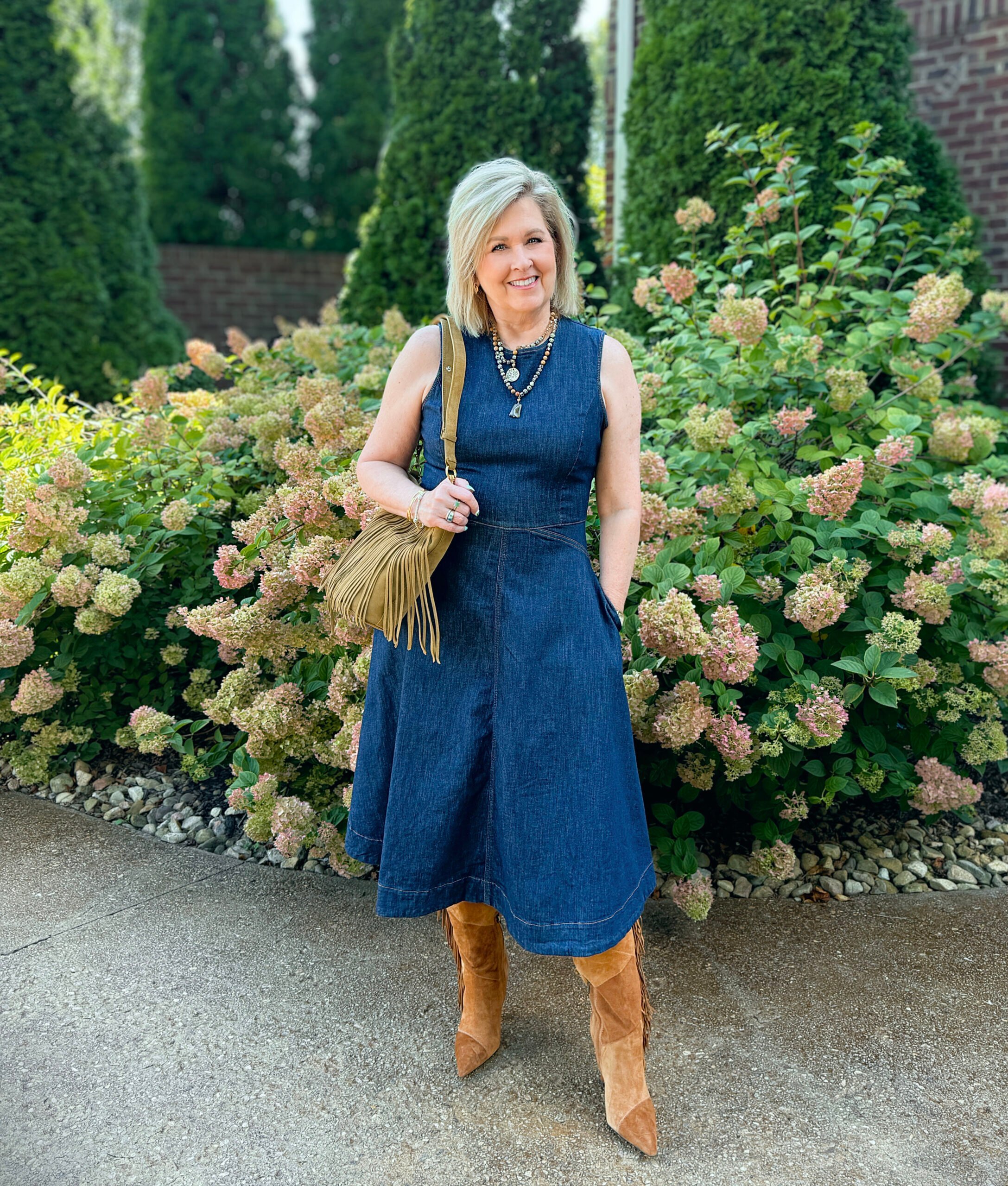 Tania Stephens wearing a fit and flare denim dress with patchwork boots and a crossbody; both with fringe