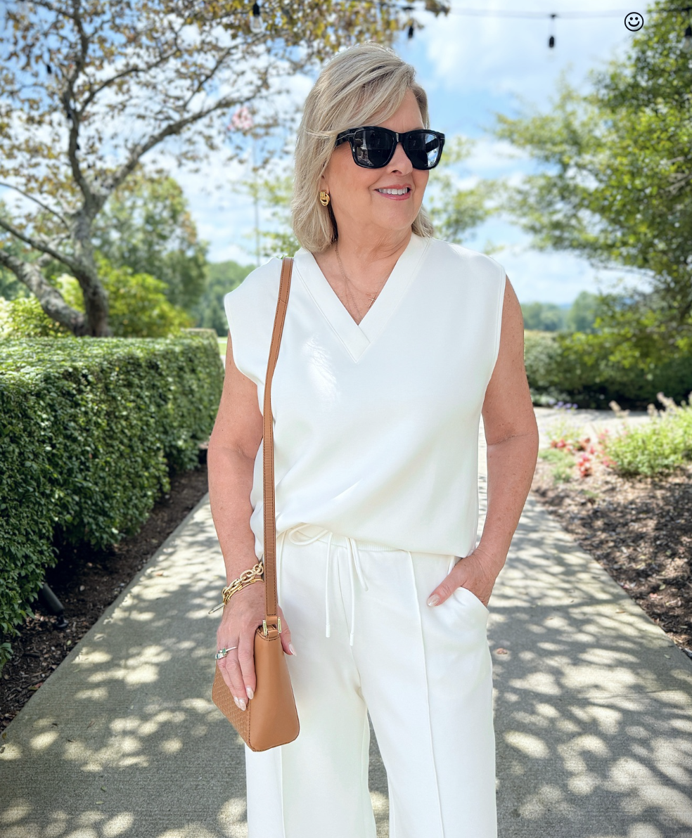 Tania Stephens walking on a path in a white v-neck top by T By Talbots