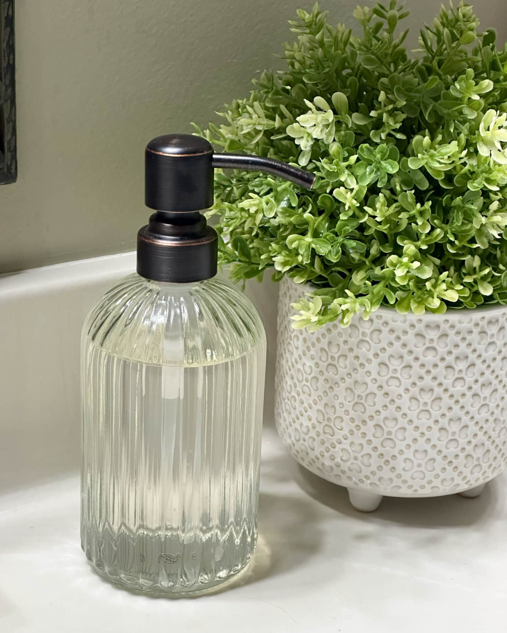 Over 50 Fashion Blogger, Tania Stephens is holding a few of her favorite things, a soap dispenser