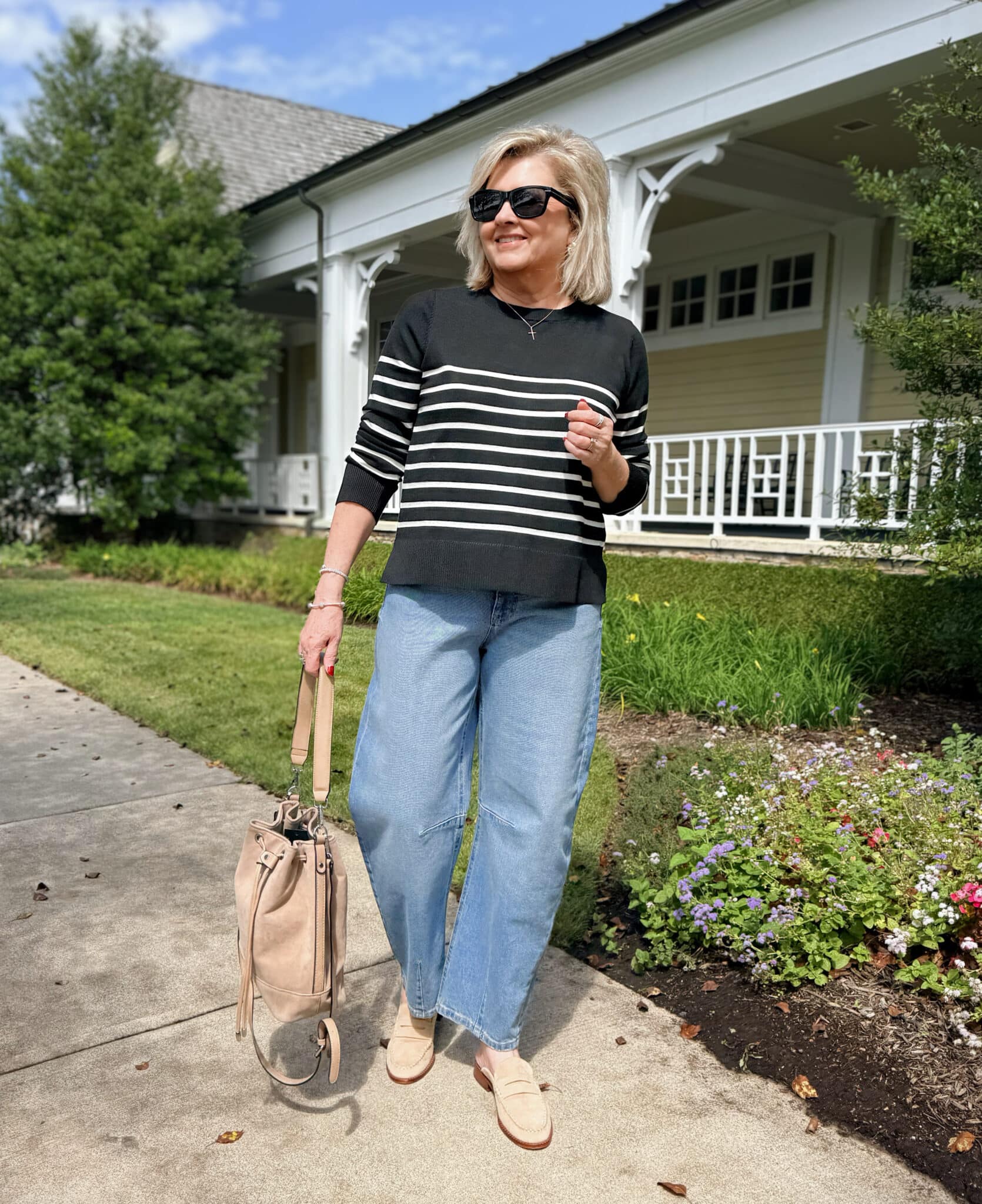 Tania Stephens wearing a  Walmart black sweater with white stripes and barrel jeans