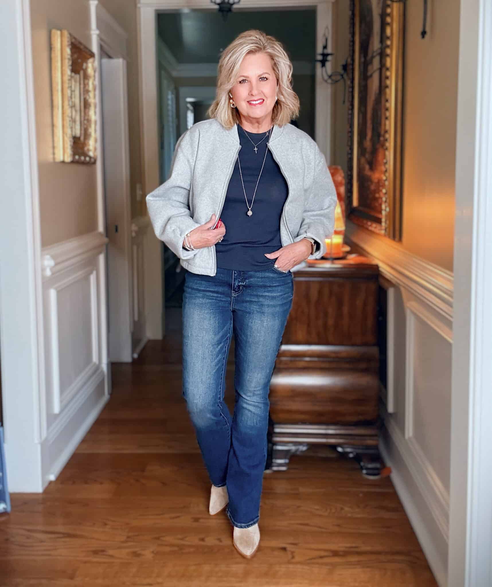 Tania wearing a navy tee and jeans with a light gray bomber jacket from Amazon