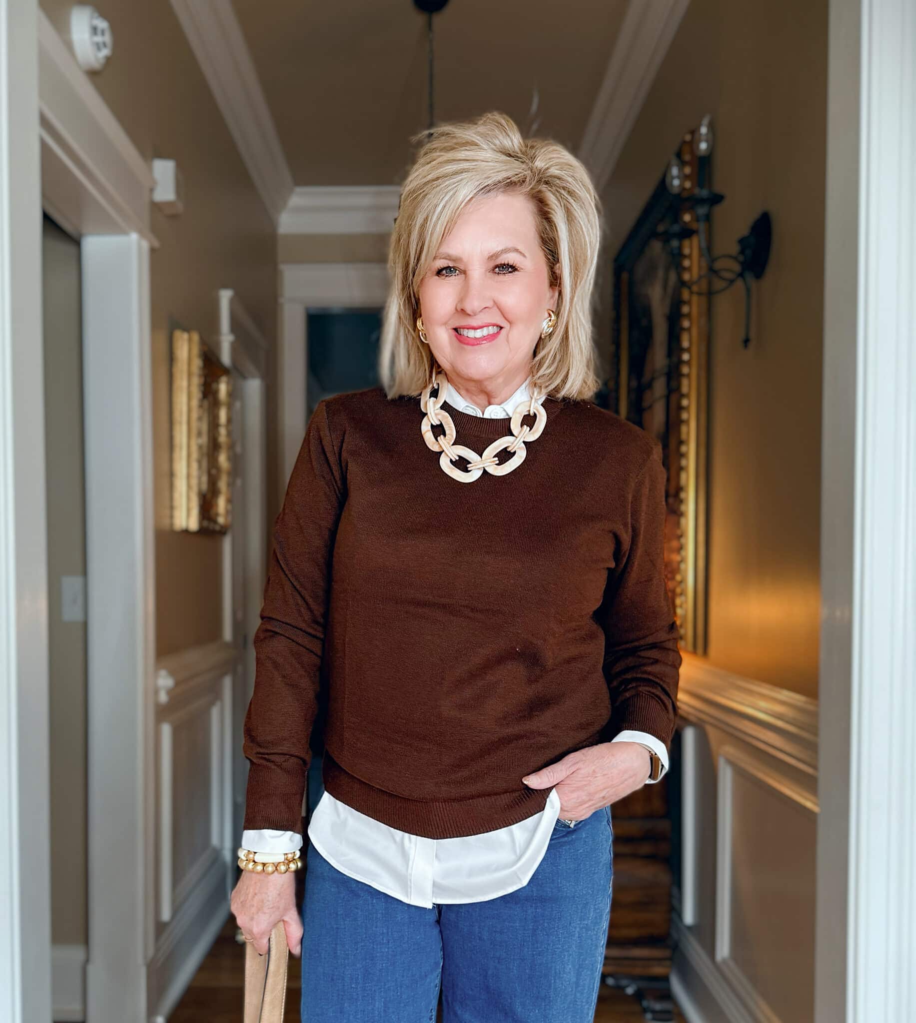 Tania is wearing an Amazon brown crewneck sweater with a white button down shirt