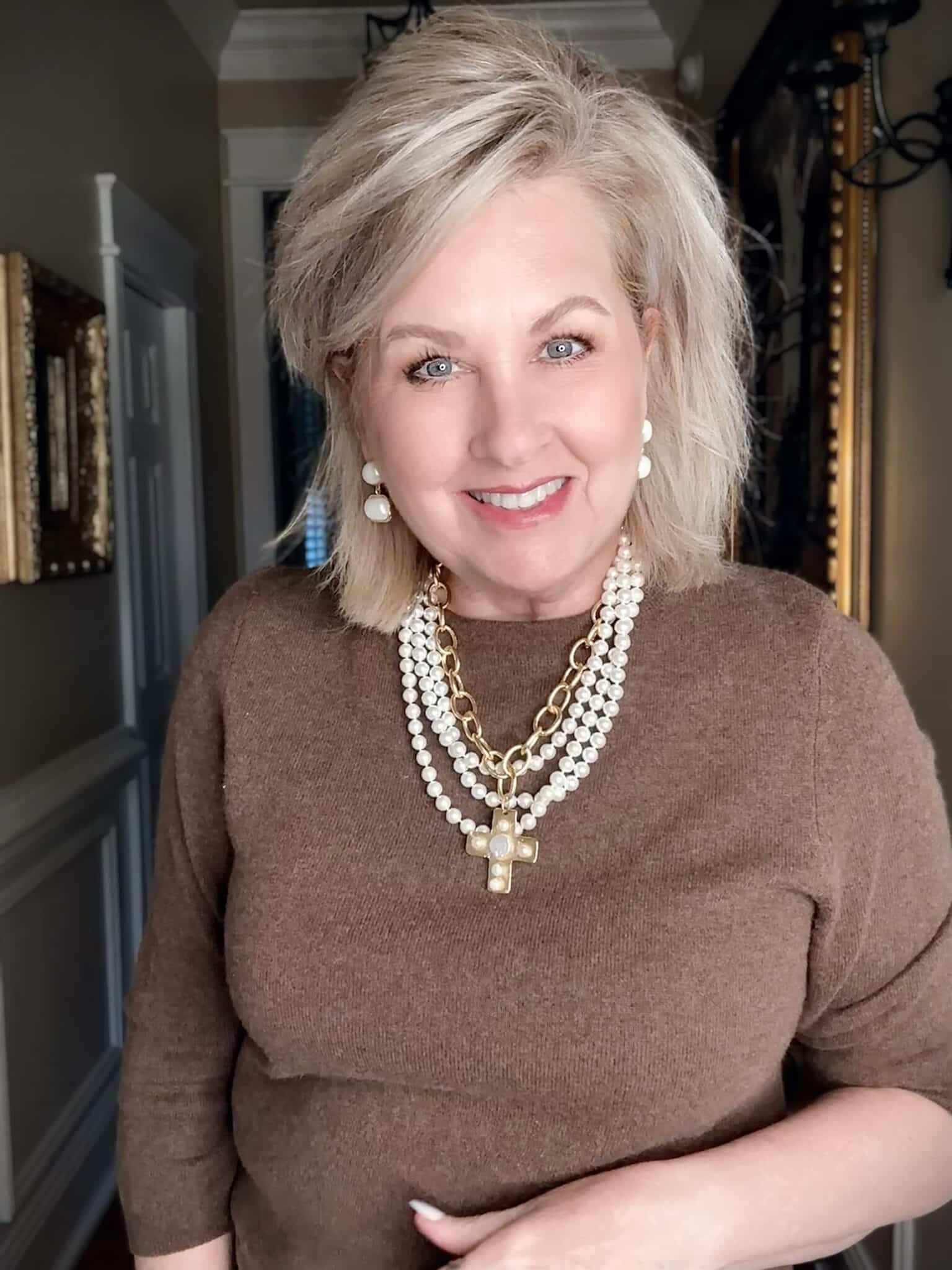 brown sweater with pearl cross multi-strand necklace