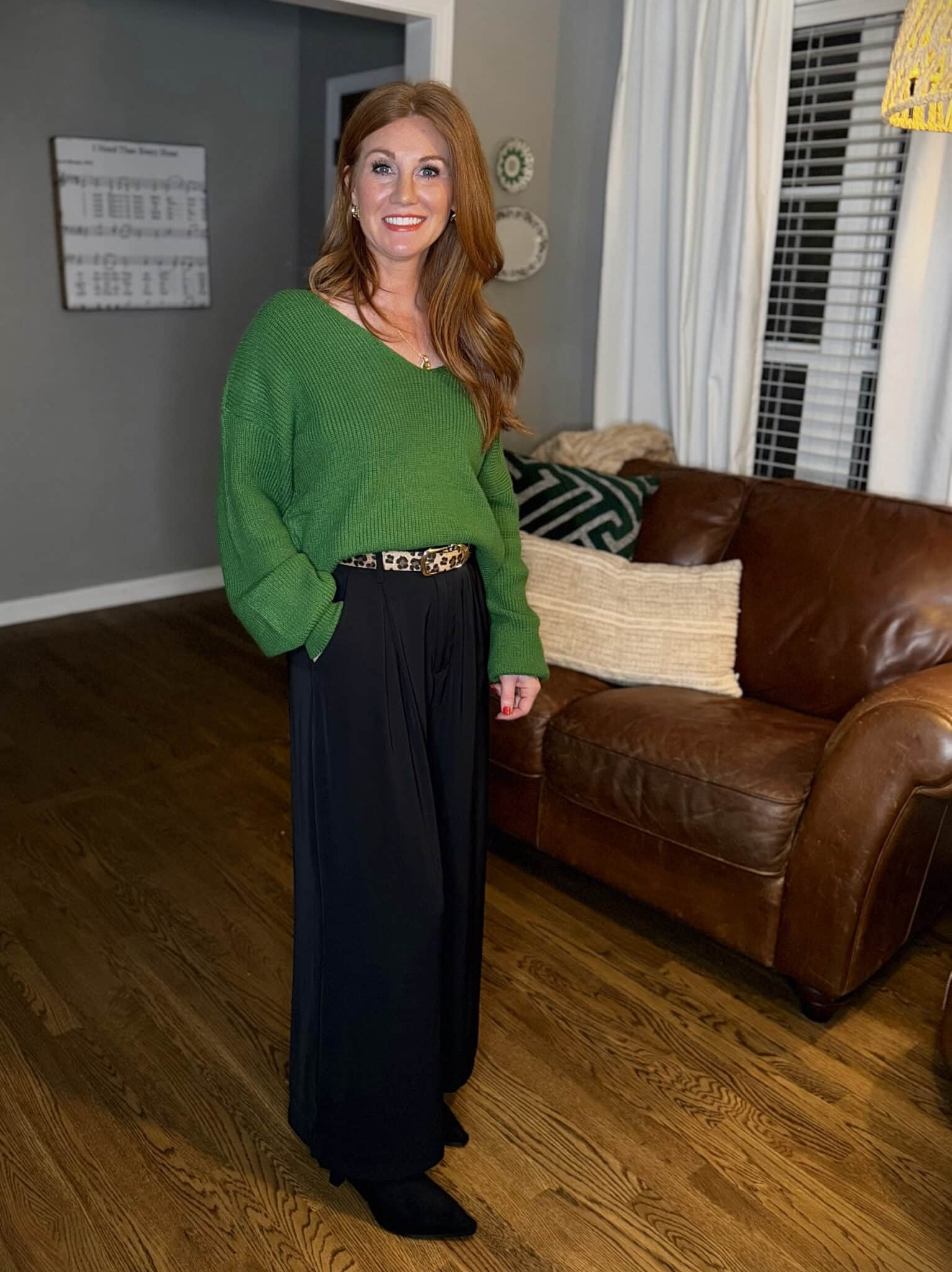 Green bow-back sweater styled with black palazzo pants on petite frame for holiday outfit