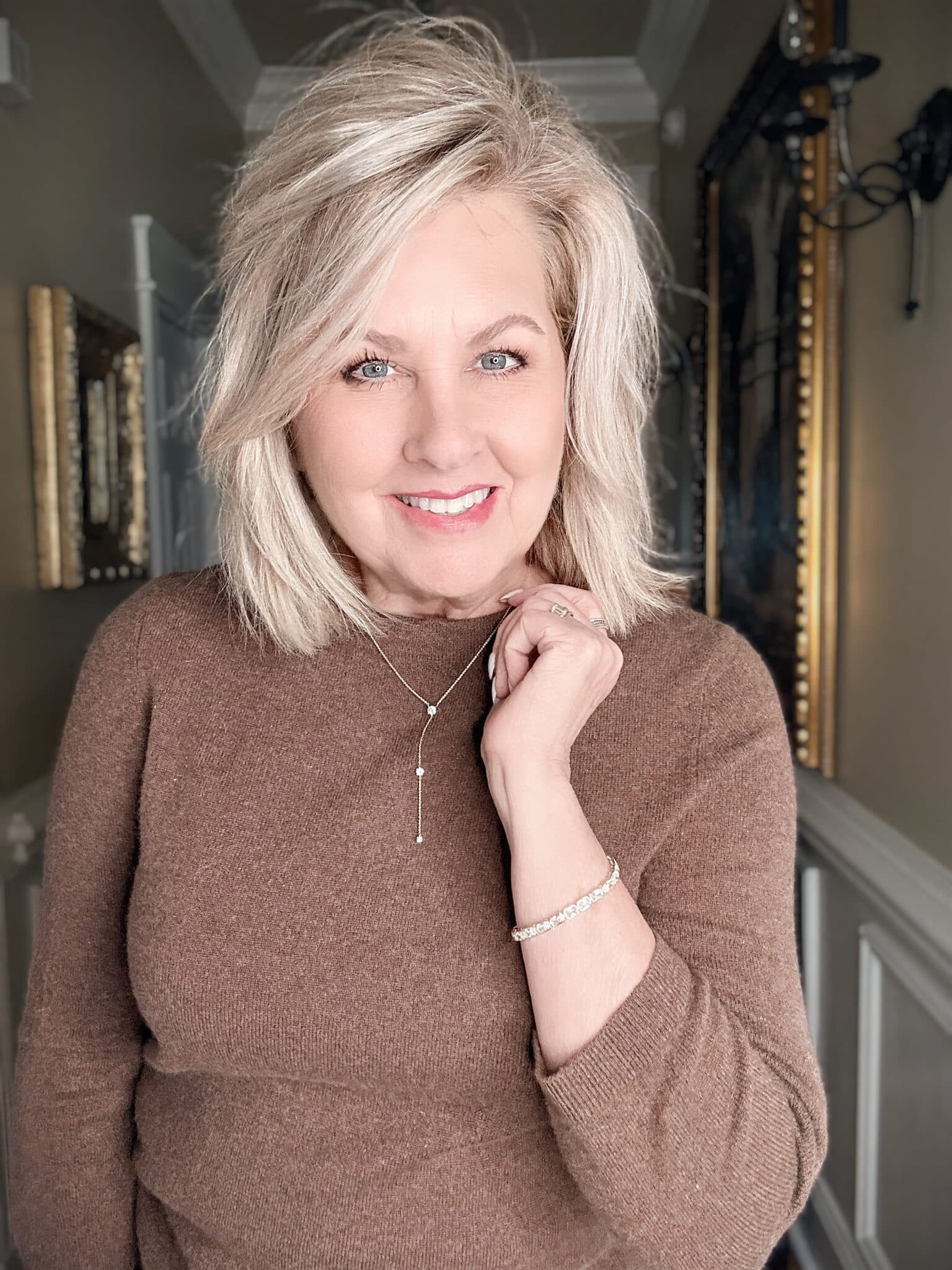 Woman in brown wearing a sparkly necklace and bracelet