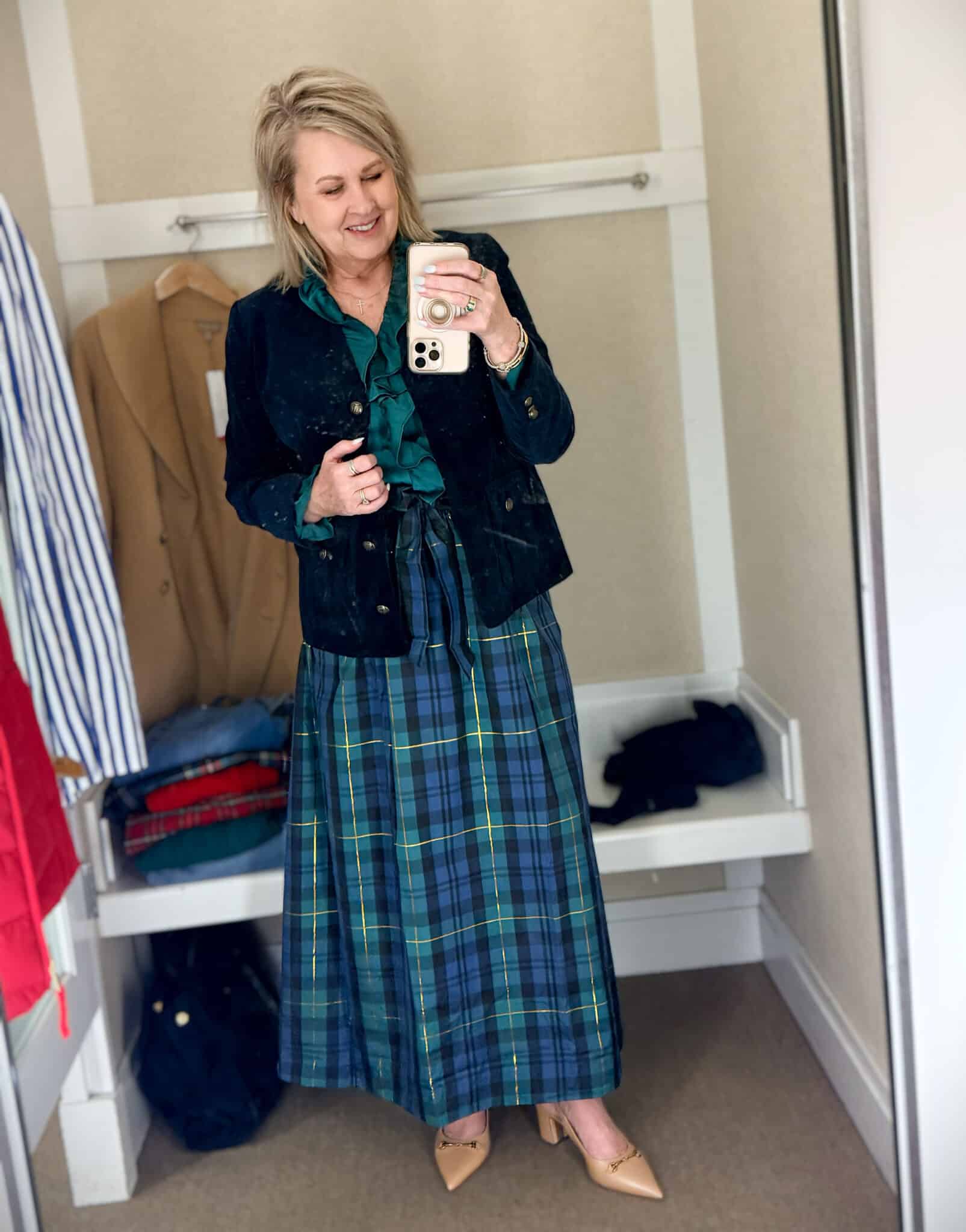 Tania trying on a navy sweater with green Christmas trees with a navy velveteen blazer and a blue and green taffeta skirt from Talbots