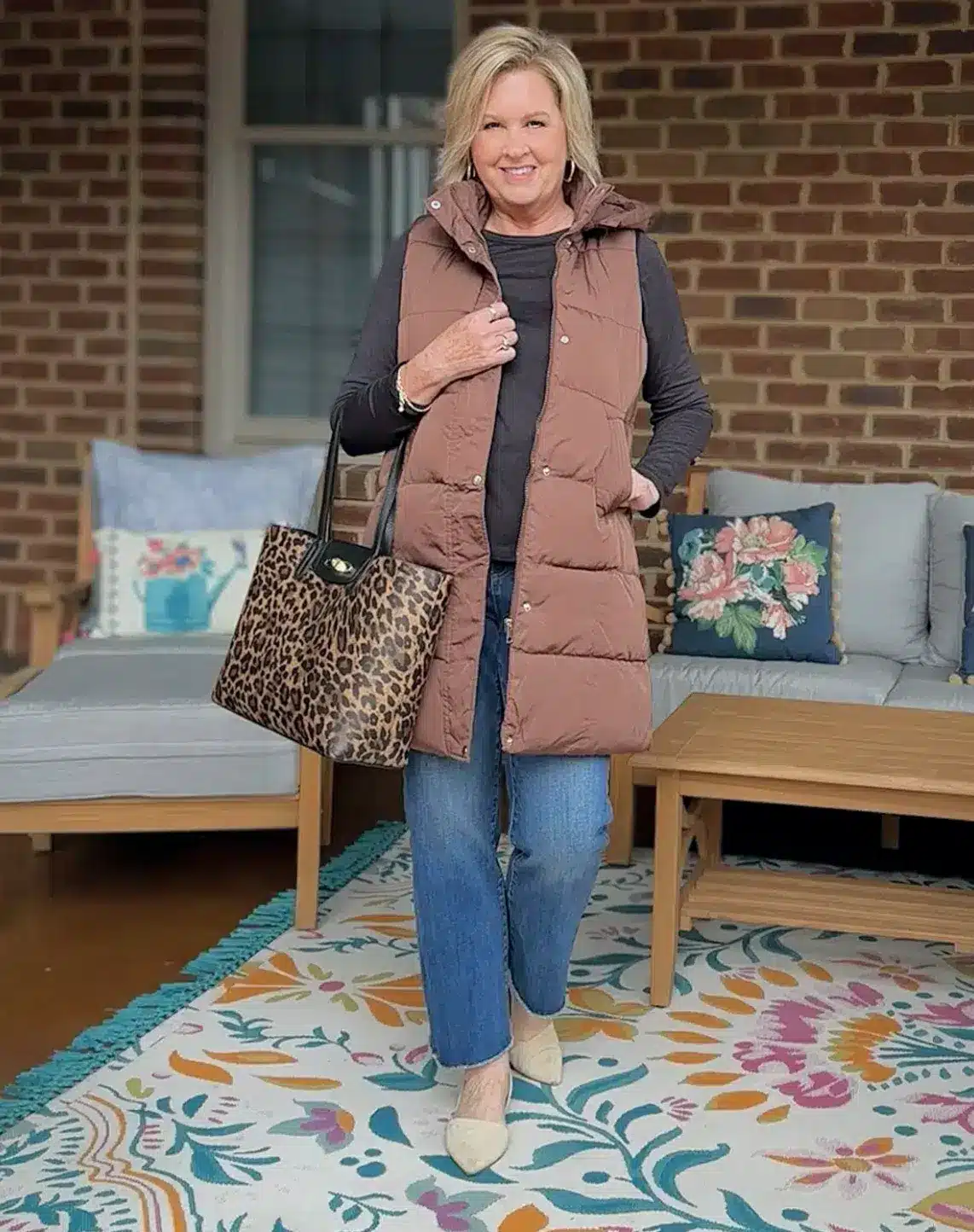 Long puffer vest in brown paired with black outfit, modern brown and black styling