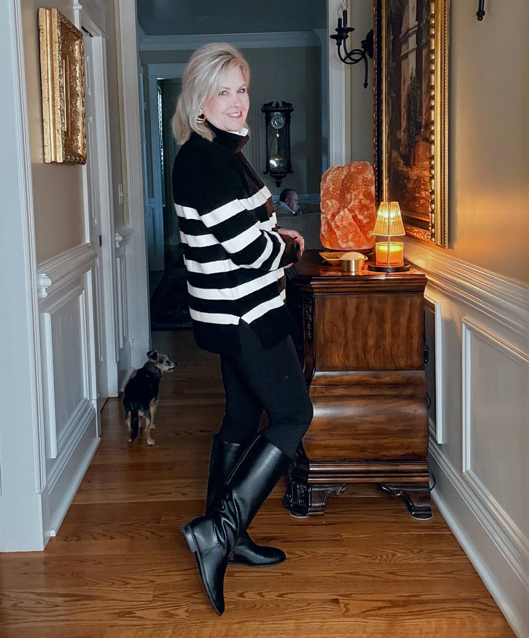 Tania showing the back of a black and white striped sweater with black leggings and riding boots from Kohl's