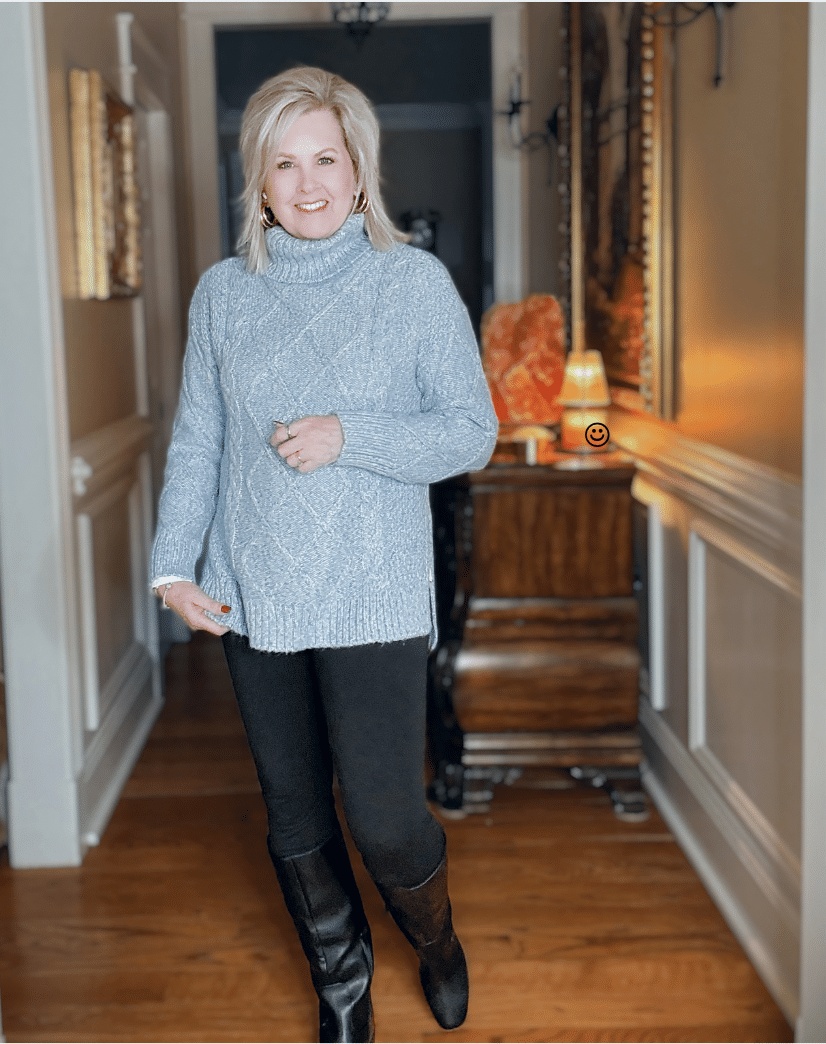 Tania wearing a icy blue cable knit cowl neck sweater with black leggings and riding boots from Kohl's