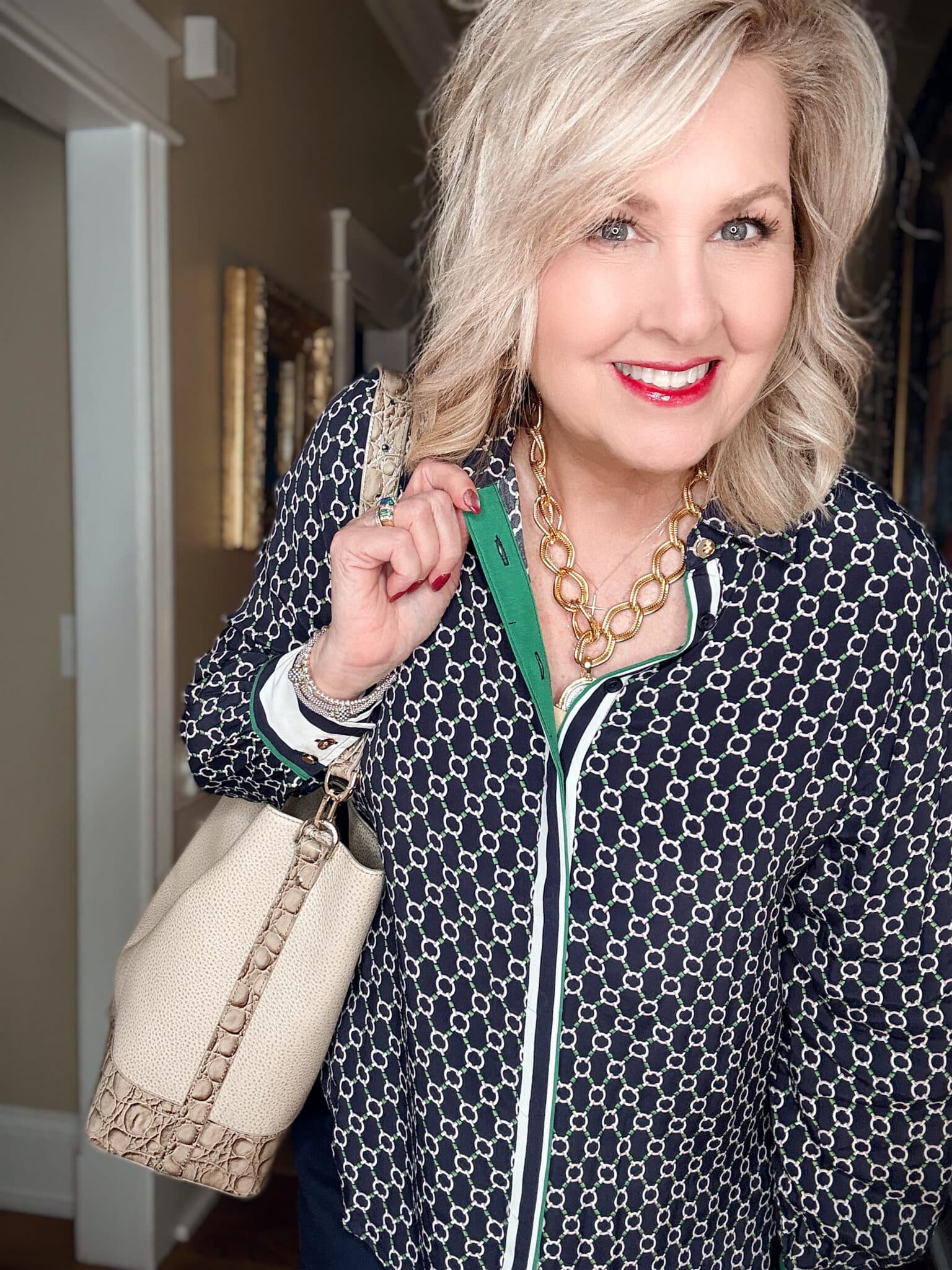 Tania wearing a blue and green blouse with a statement necklace from Susan Shaw
