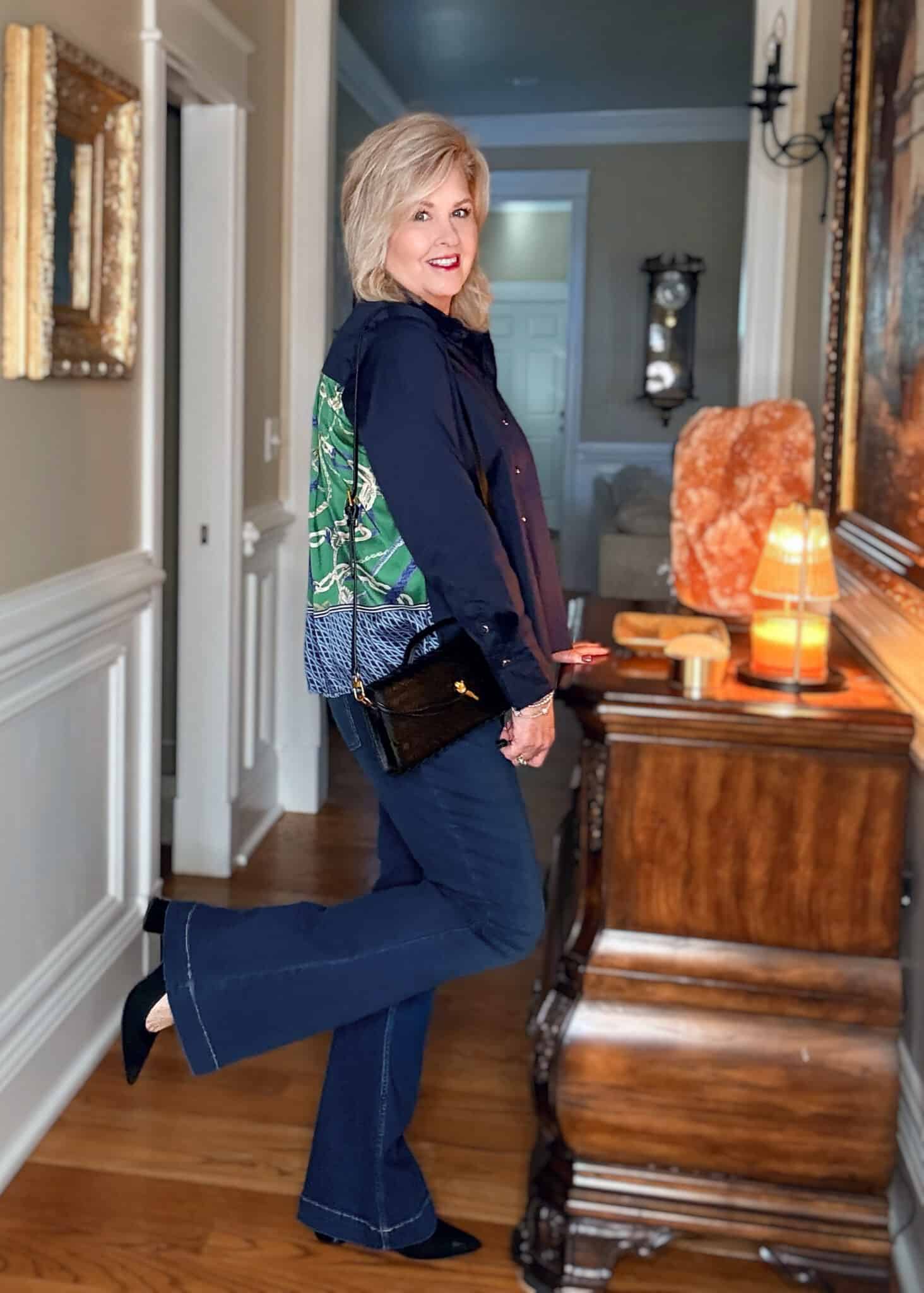 Tania wearing a navy top with faux silk twill pleated back and dark wash jeans with black heels