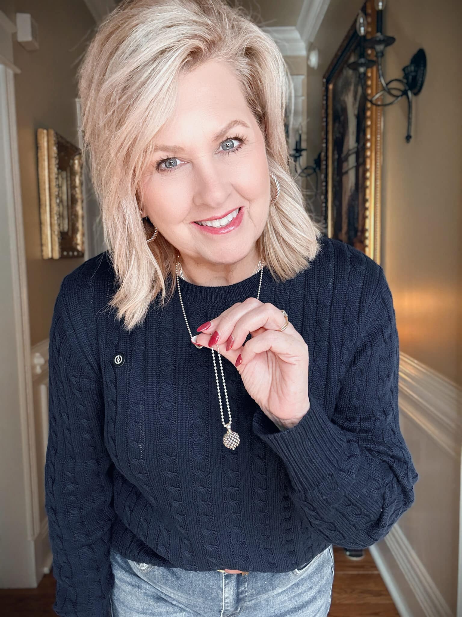 Tania wearing a navy cableknit sweater with a LAGOS necklace