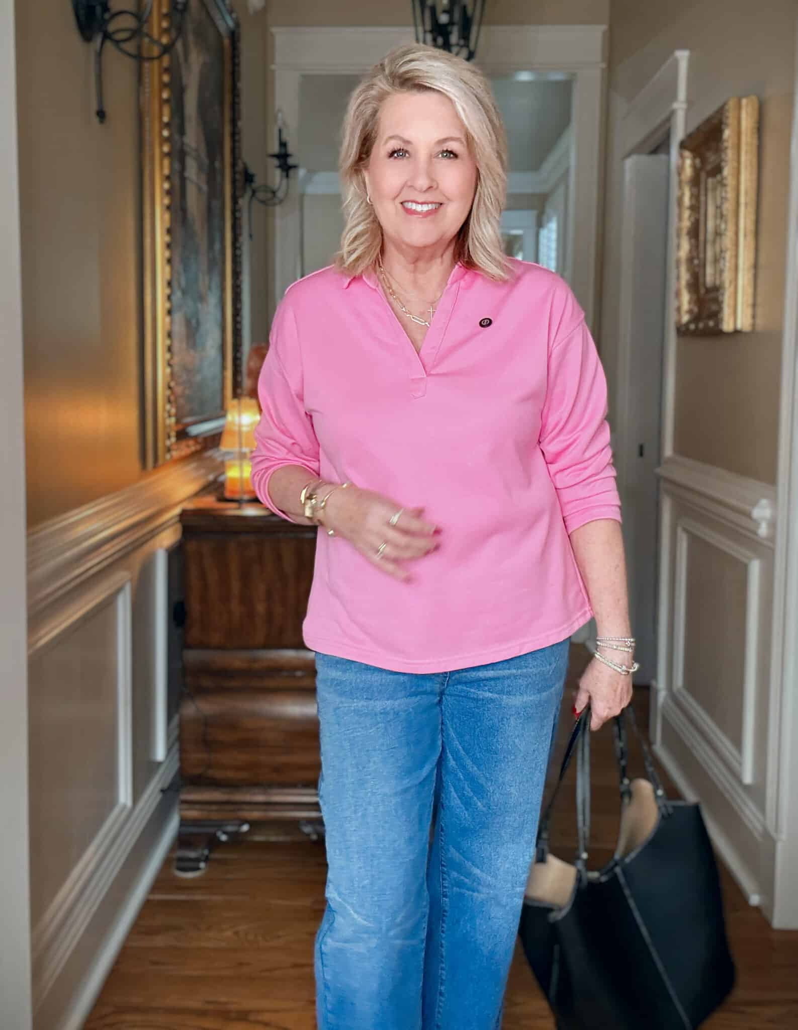 Tania wearing a bright pink polo style top with jeans
