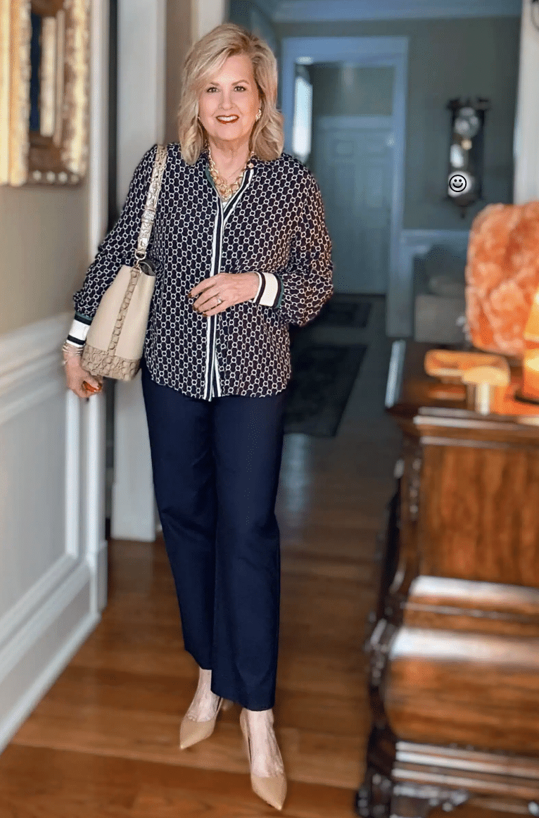 Tania wearing a blue and green blouse with navy pants and nude heels