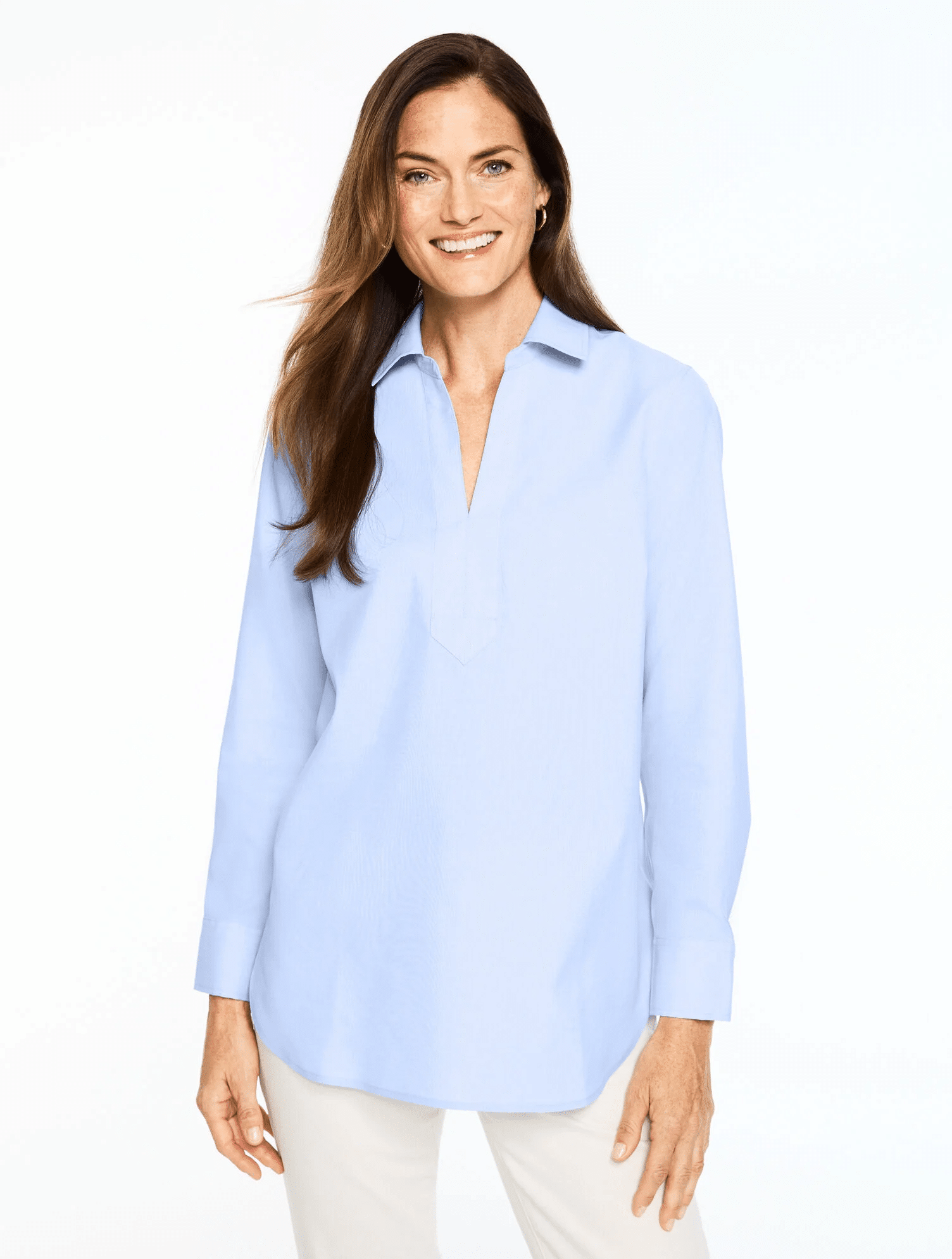 Woman over 50 wearing a crisp non-iron tunic popover with slim pants for a polished and comfortable everyday outfit
