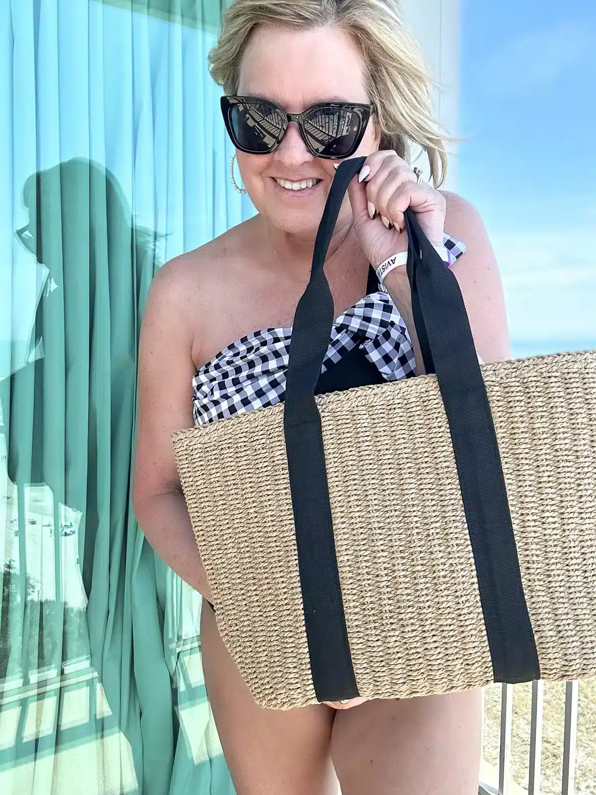 TANIA CARRYING A STRAW TOTE BEACH BAG