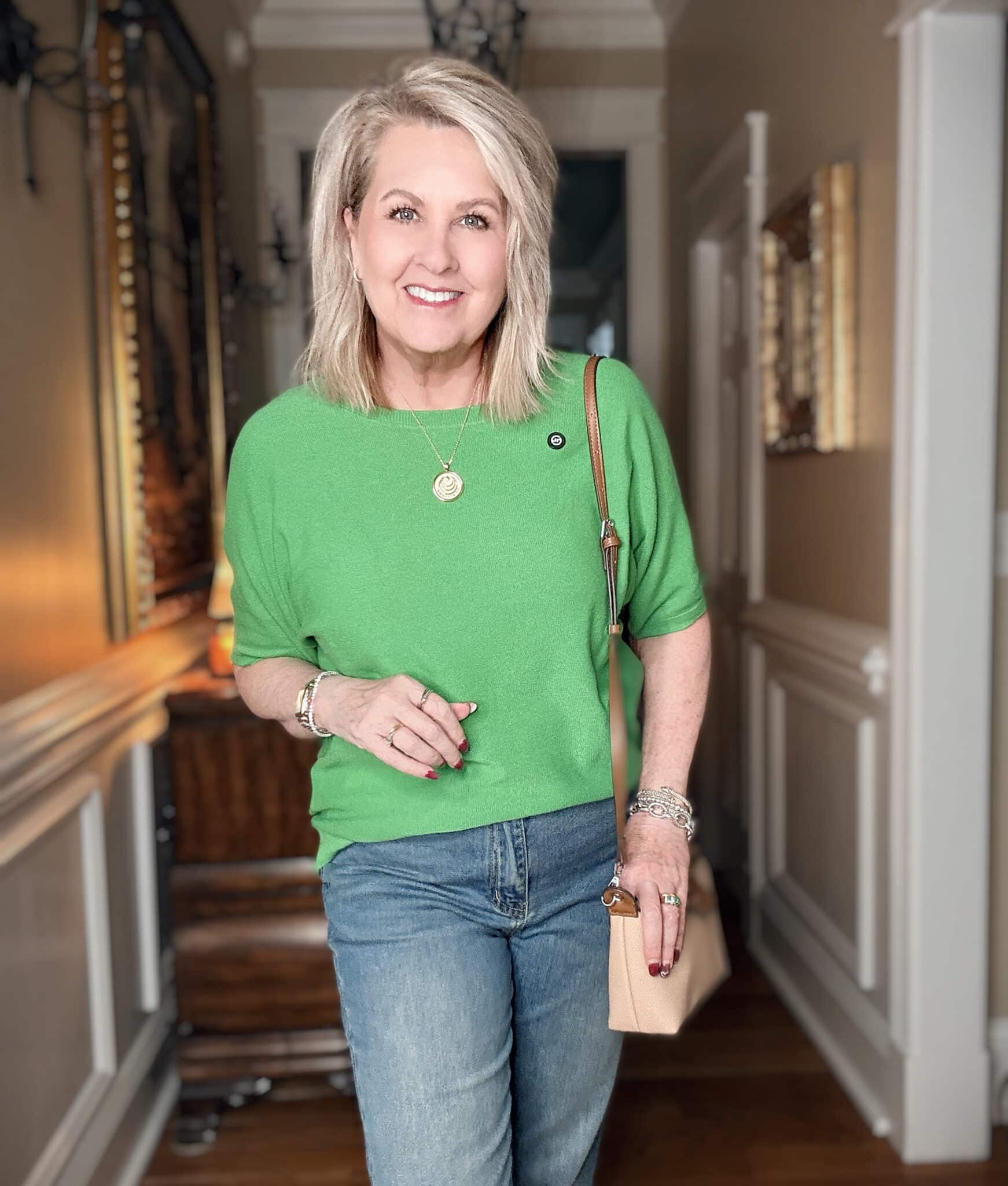 Tania wearing a green sweater with a small crossbody bag
