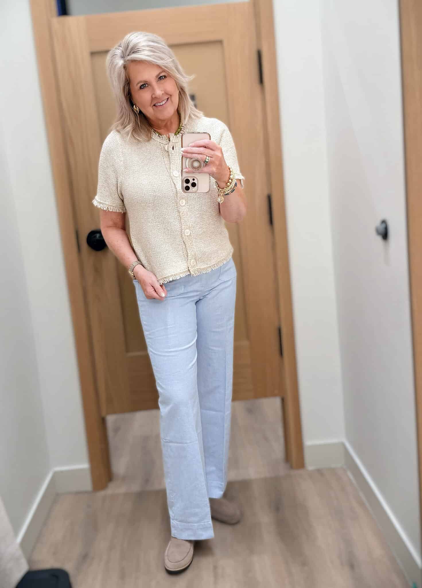 Tania wearing a beige fringed cardigan with blue striped pants from J.Crew Factory